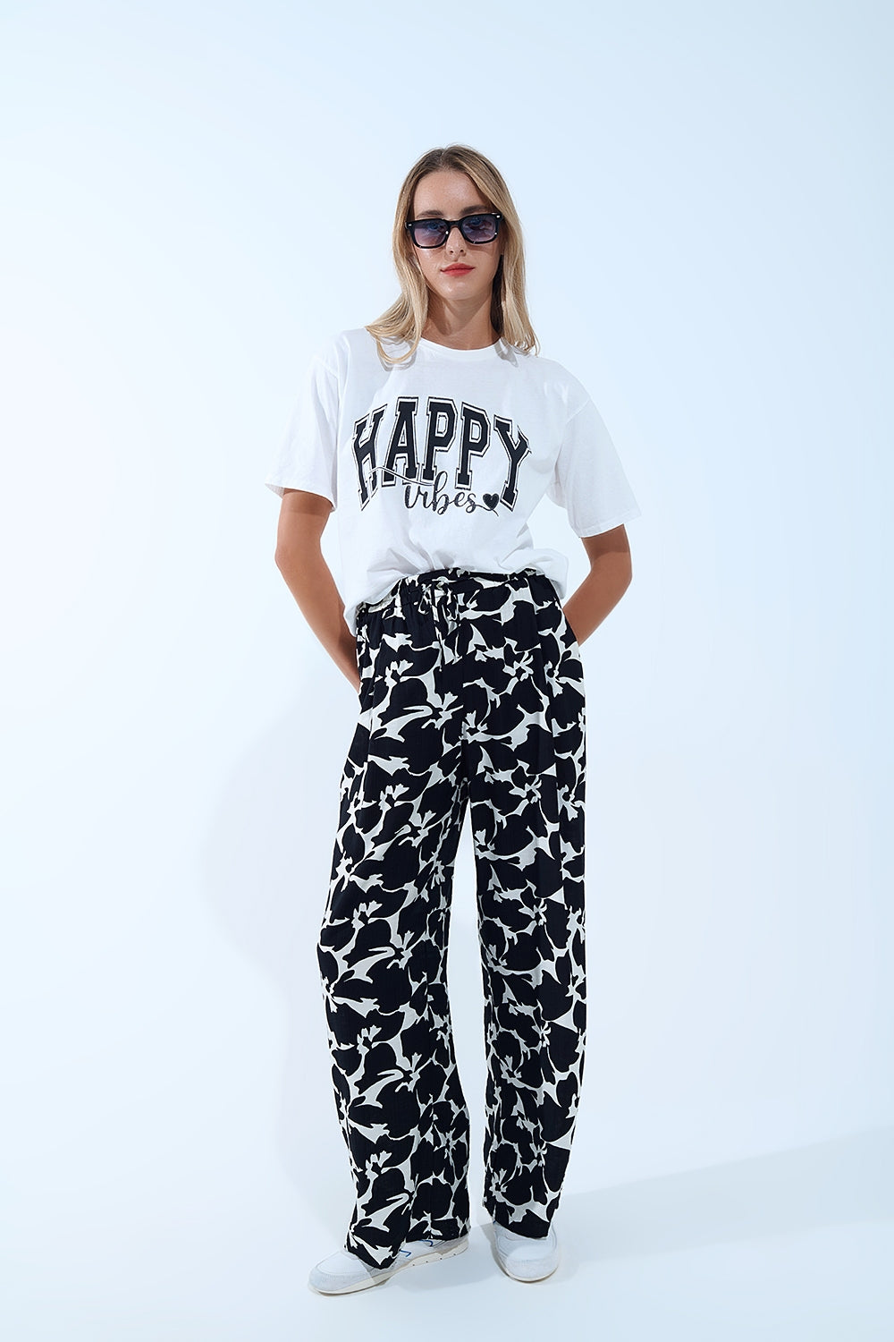 Look con pantalón estampado y camiseta blanca con mensaje