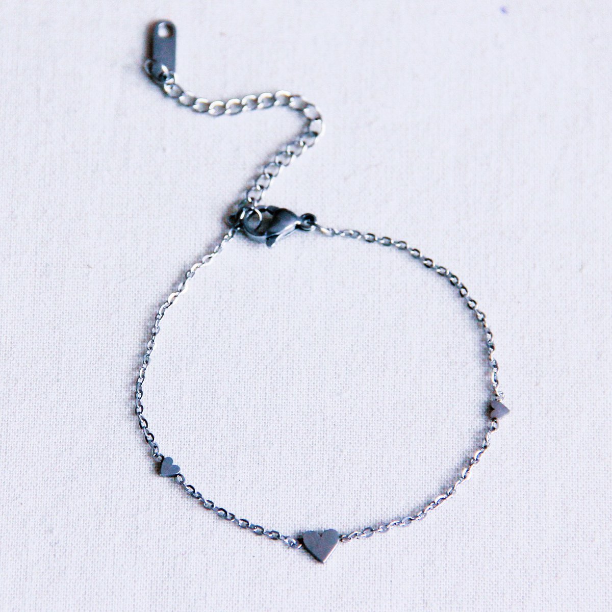 Pulsera fina de acero inoxidable plateado con tres mini corazones diseño elegante y moderno