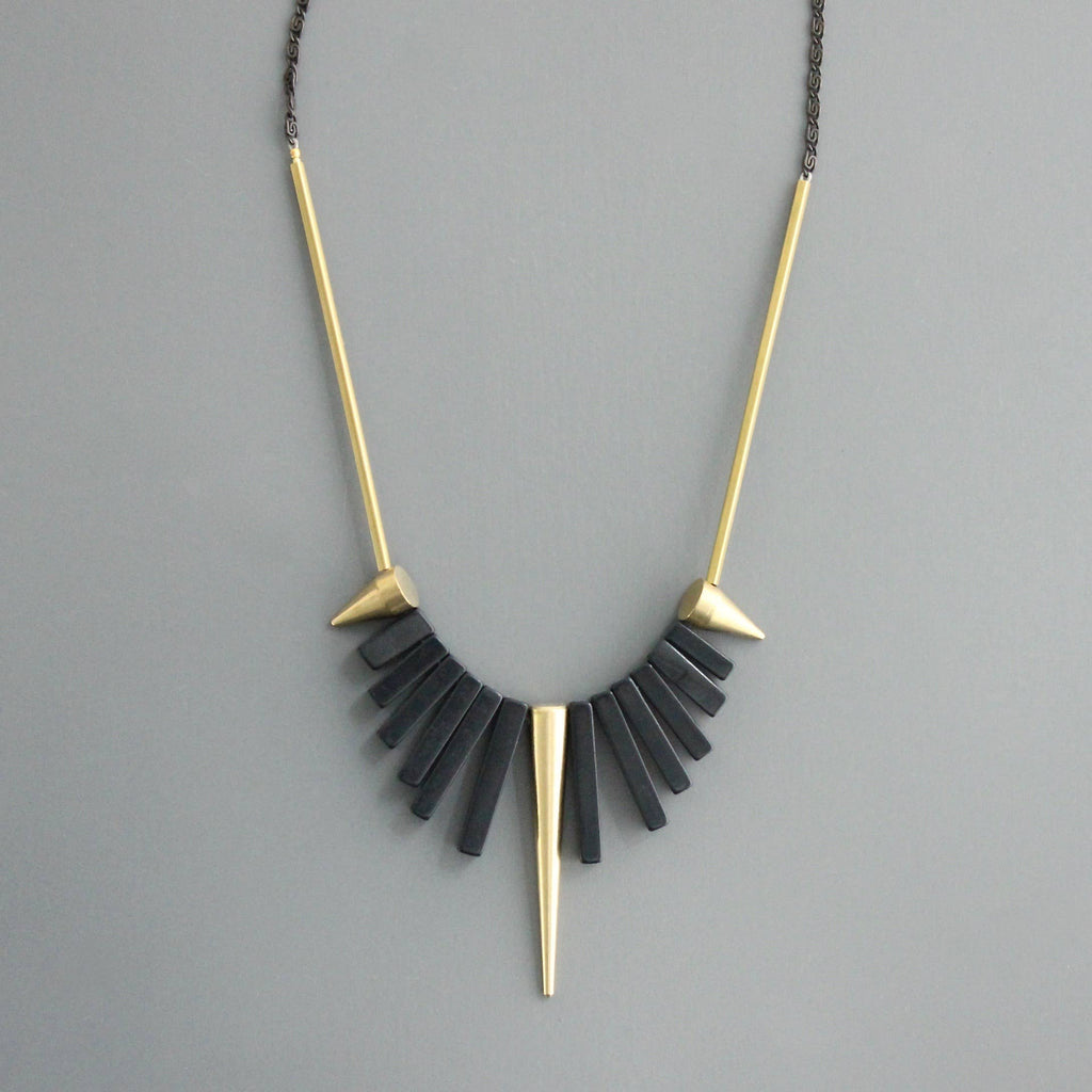 Collar corto de David Aubrey con piedras de ágata negra y detalles de latón dorado. Diseño artesanal exclusivo con extensor. Disponible en Ivoluxt.