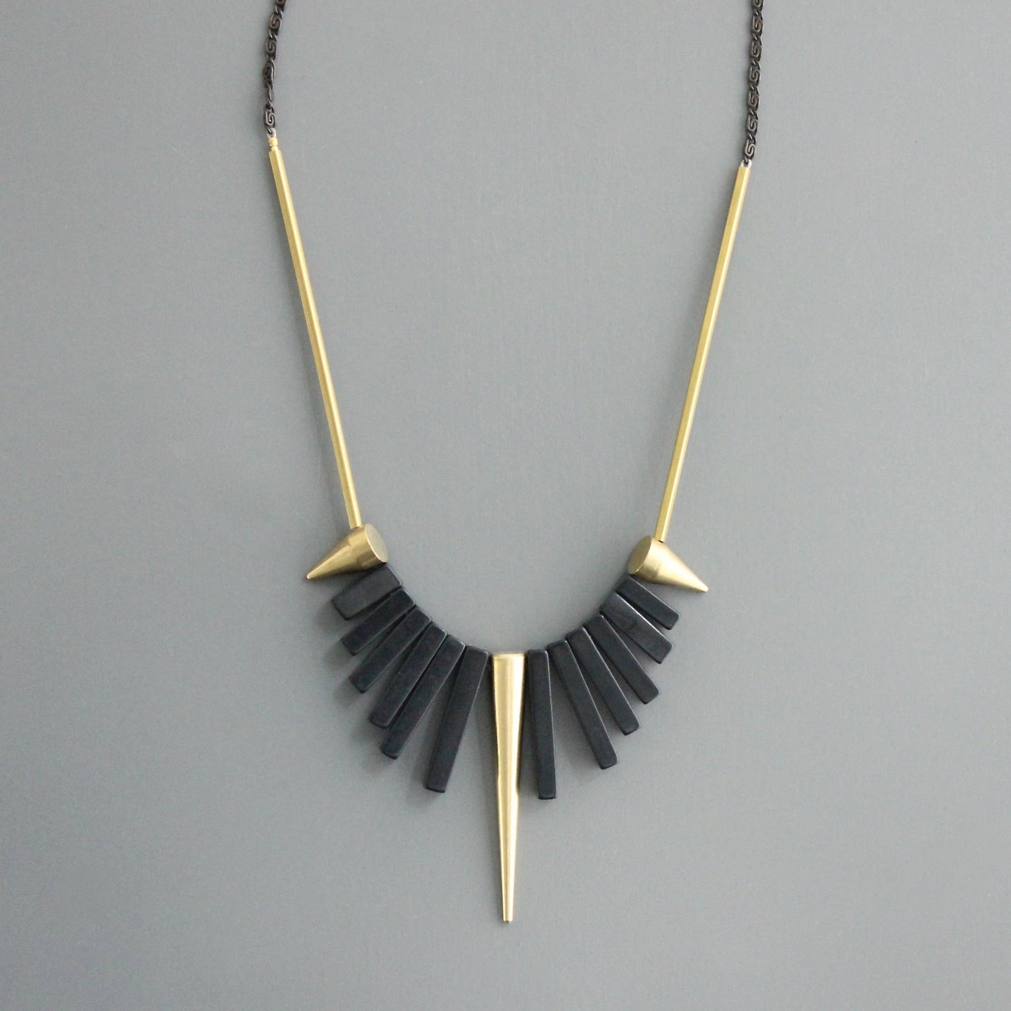 Collar corto de David Aubrey con piedras de ágata negra y detalles de latón dorado. Diseño artesanal exclusivo con extensor. Disponible en Ivoluxt.