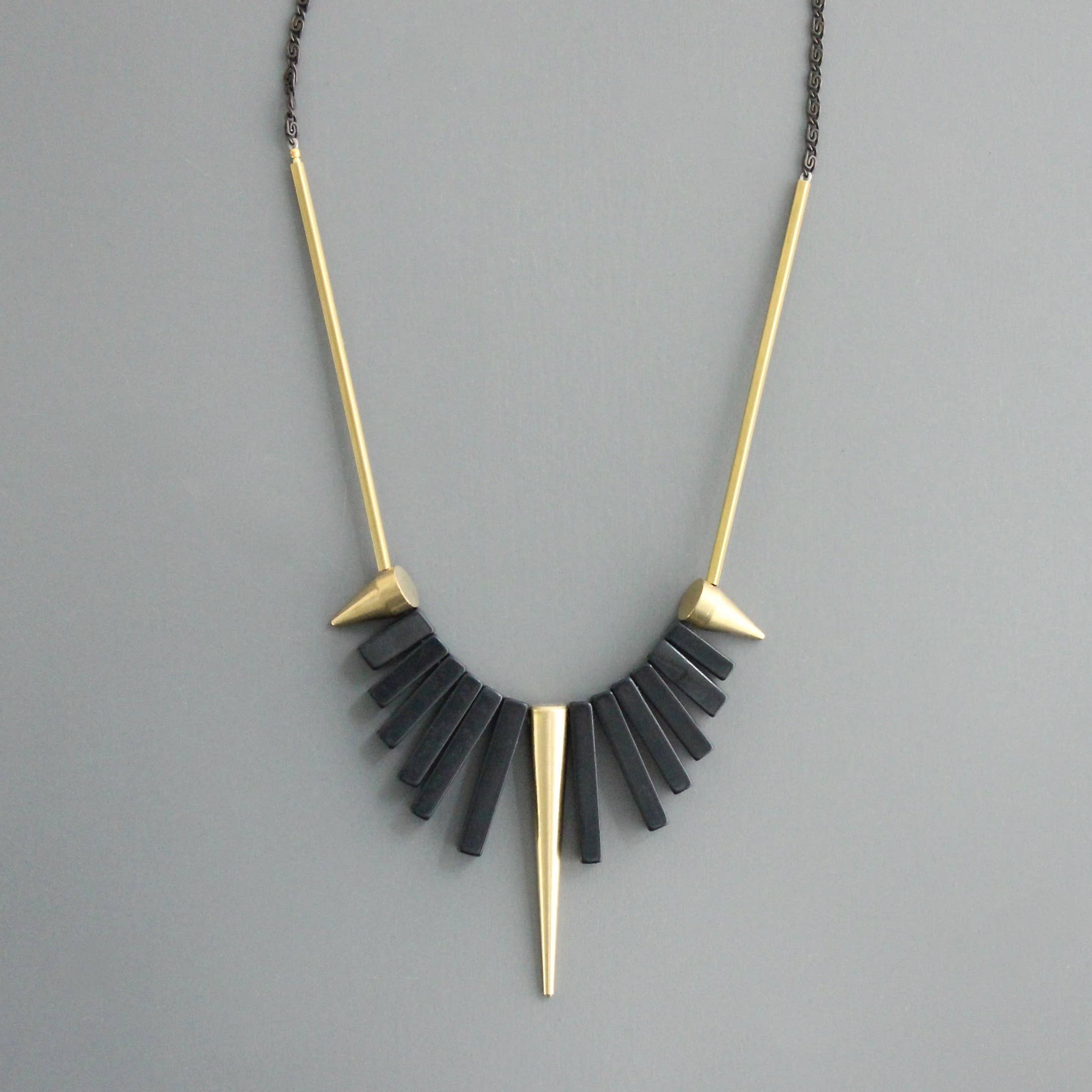 Collar corto de David Aubrey con piedras de ágata negra y detalles de latón dorado. Diseño artesanal exclusivo con extensor. Disponible en Ivoluxt.