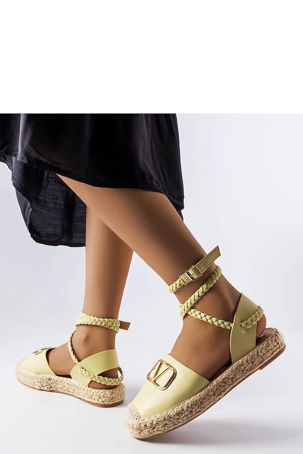  Alpargatas de verano color beige con cierre trenzado y plataforma plana de esparto, combinadas con vestido negro.