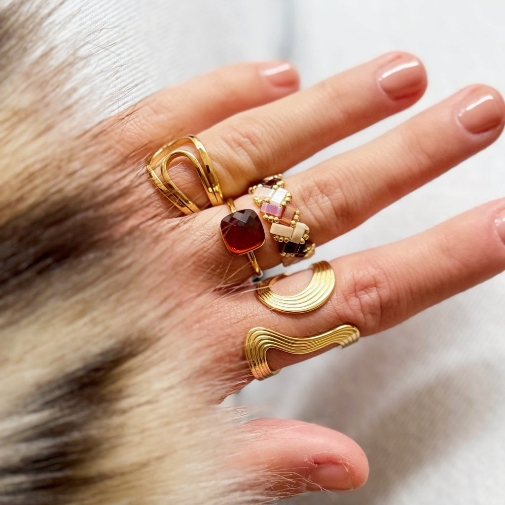 Anillo tejido con cuentas Tila cuadradas en colores marrón, beige y blanco con patrón de espiga y detalles dorados.