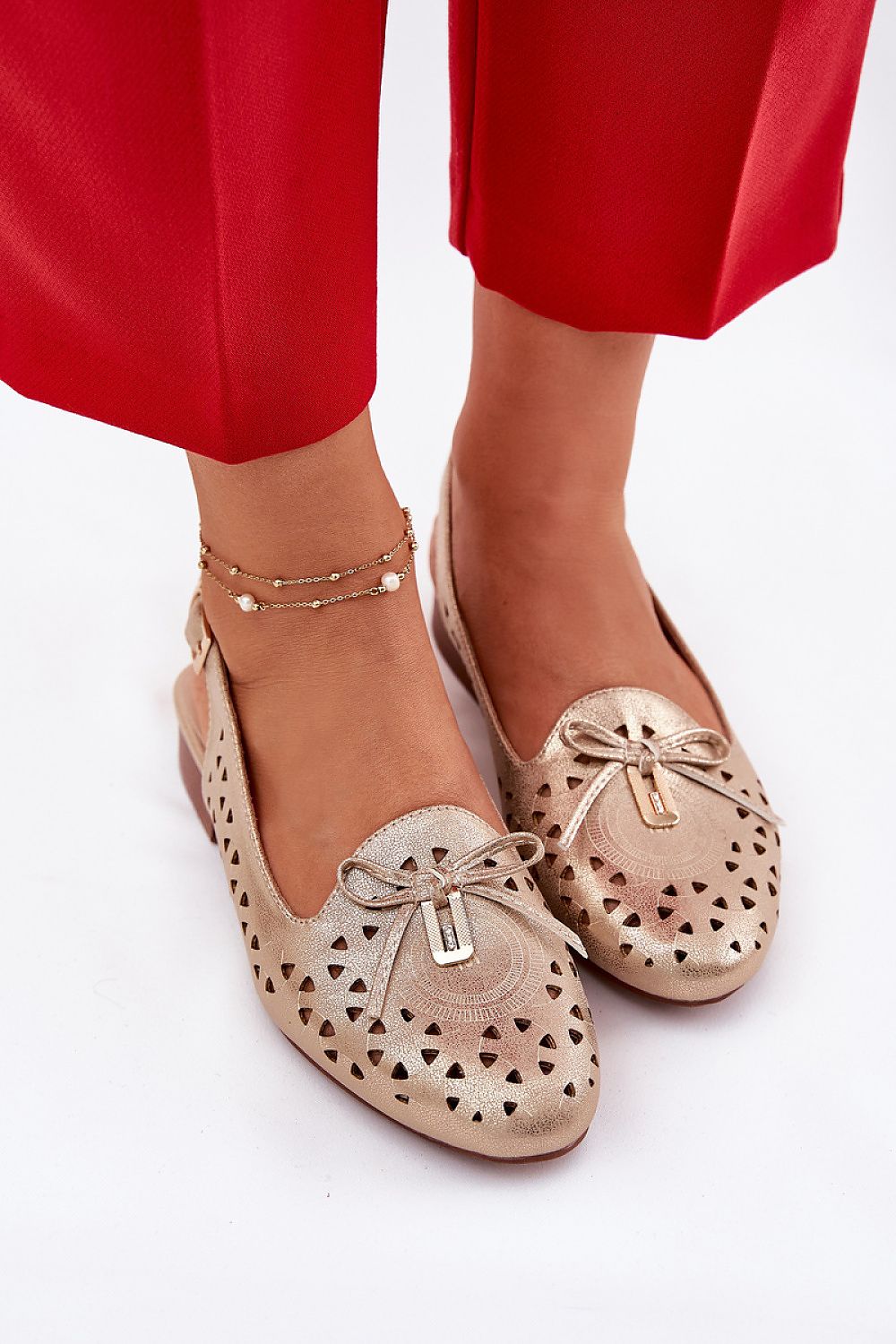 Zapatos planos dorados troquelados con lazo decorativo para mujer