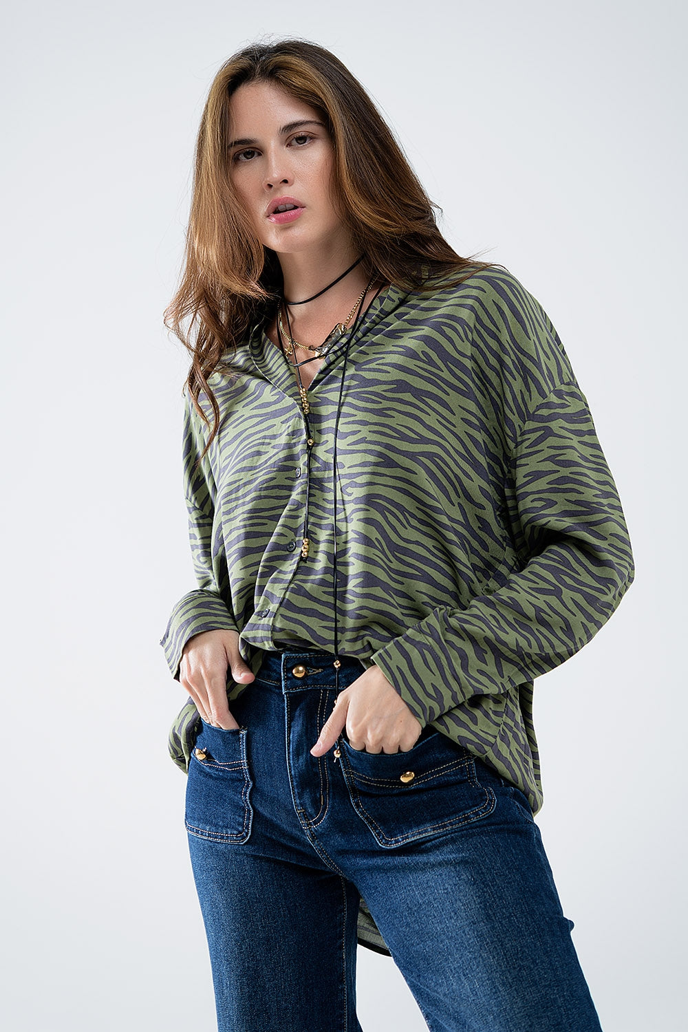 Detalle de botones y tejido ligero en blusa animal print verde