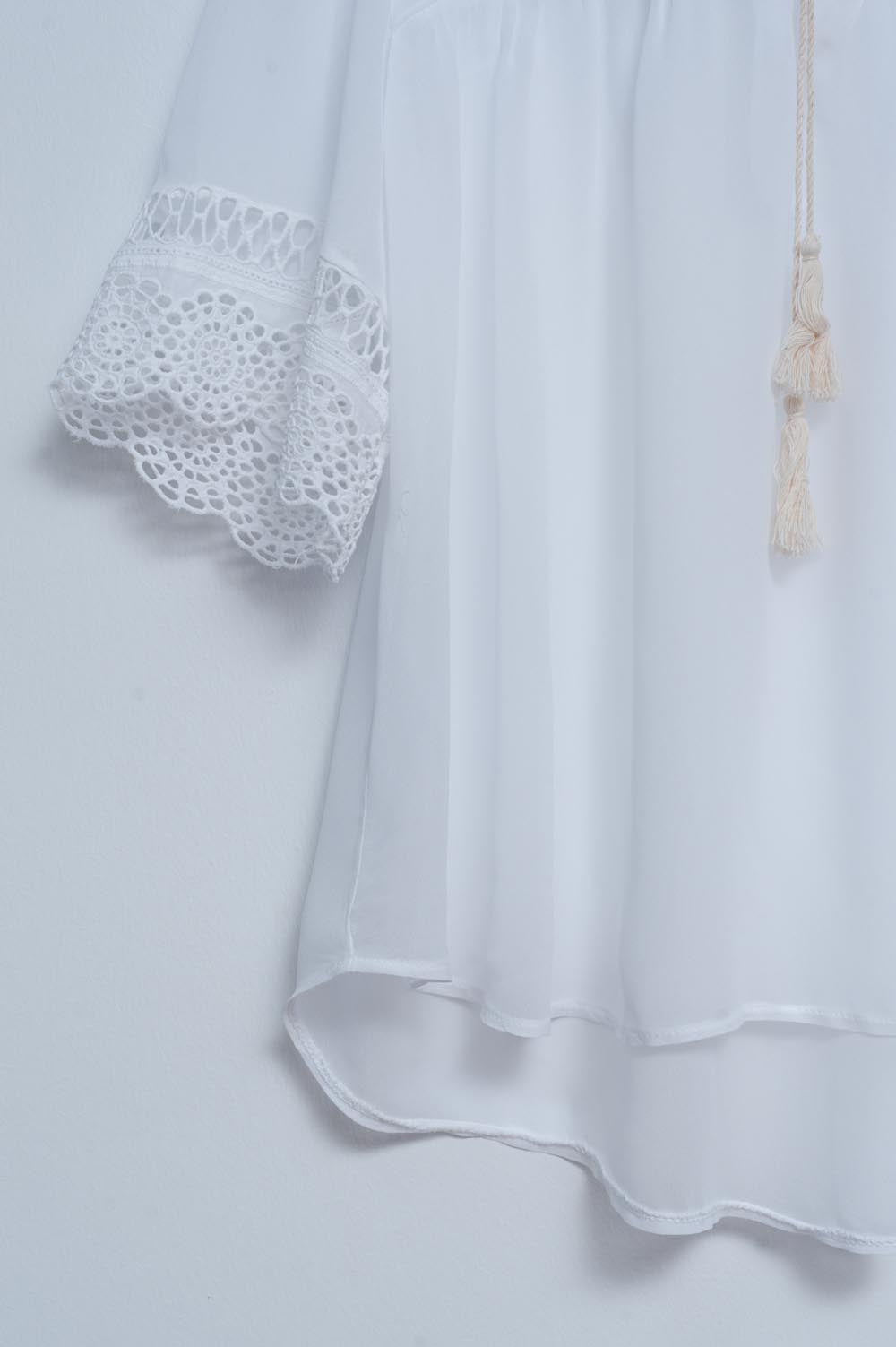 Blusa blanca con lazadas en la parte delantera y bordados