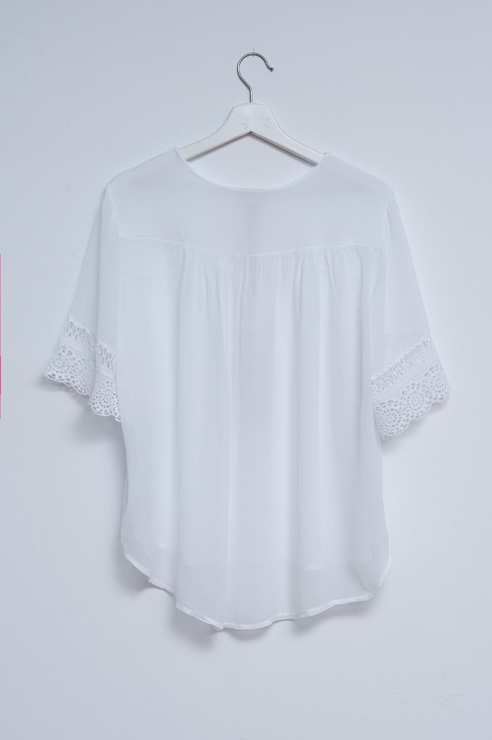 Blusa blanca con lazadas en la parte delantera y bordados