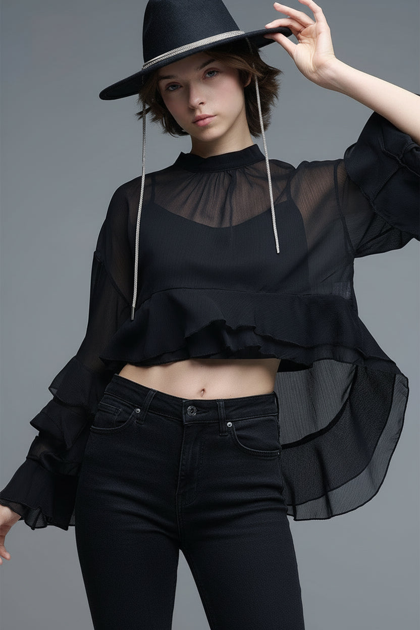 Blusa negra de gasa con volantes y transparencias estilo capa