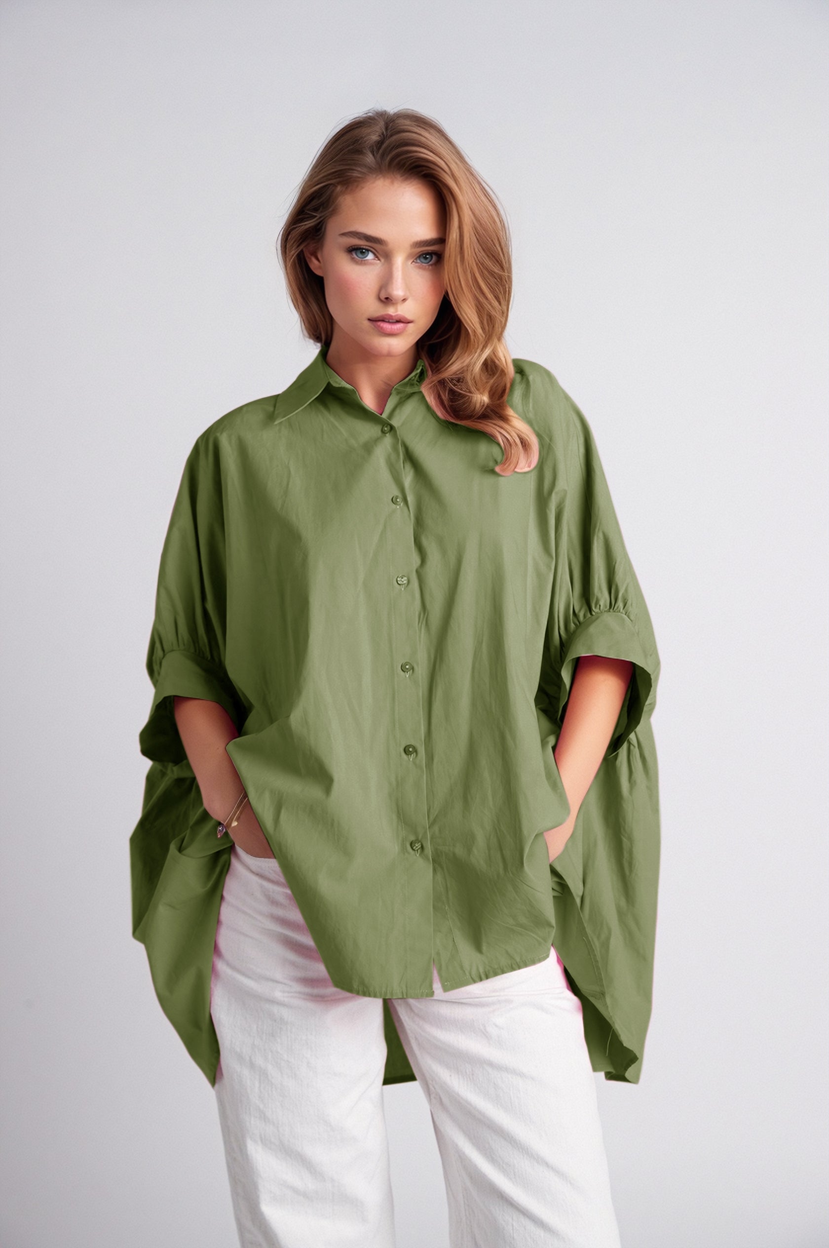 Modelo luciendo blusa de algodón verde muy amplia con detalle de manga fruncida.