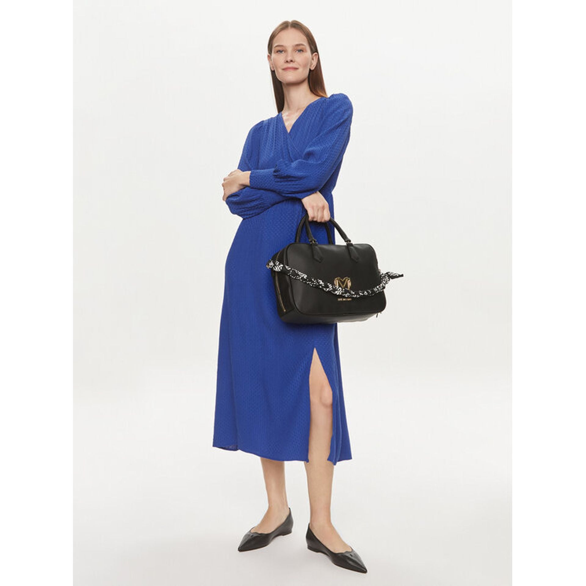Mujer con vestido azul llevando bolso Love Moschino negro con logo dorado