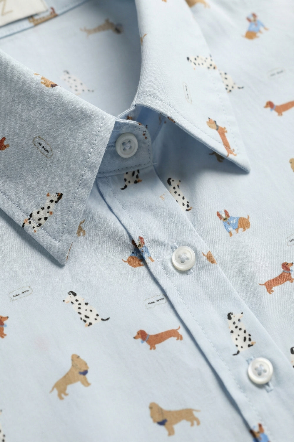 camisa azul claro 100% algodón con estampado de perritos y vaqueros azules.