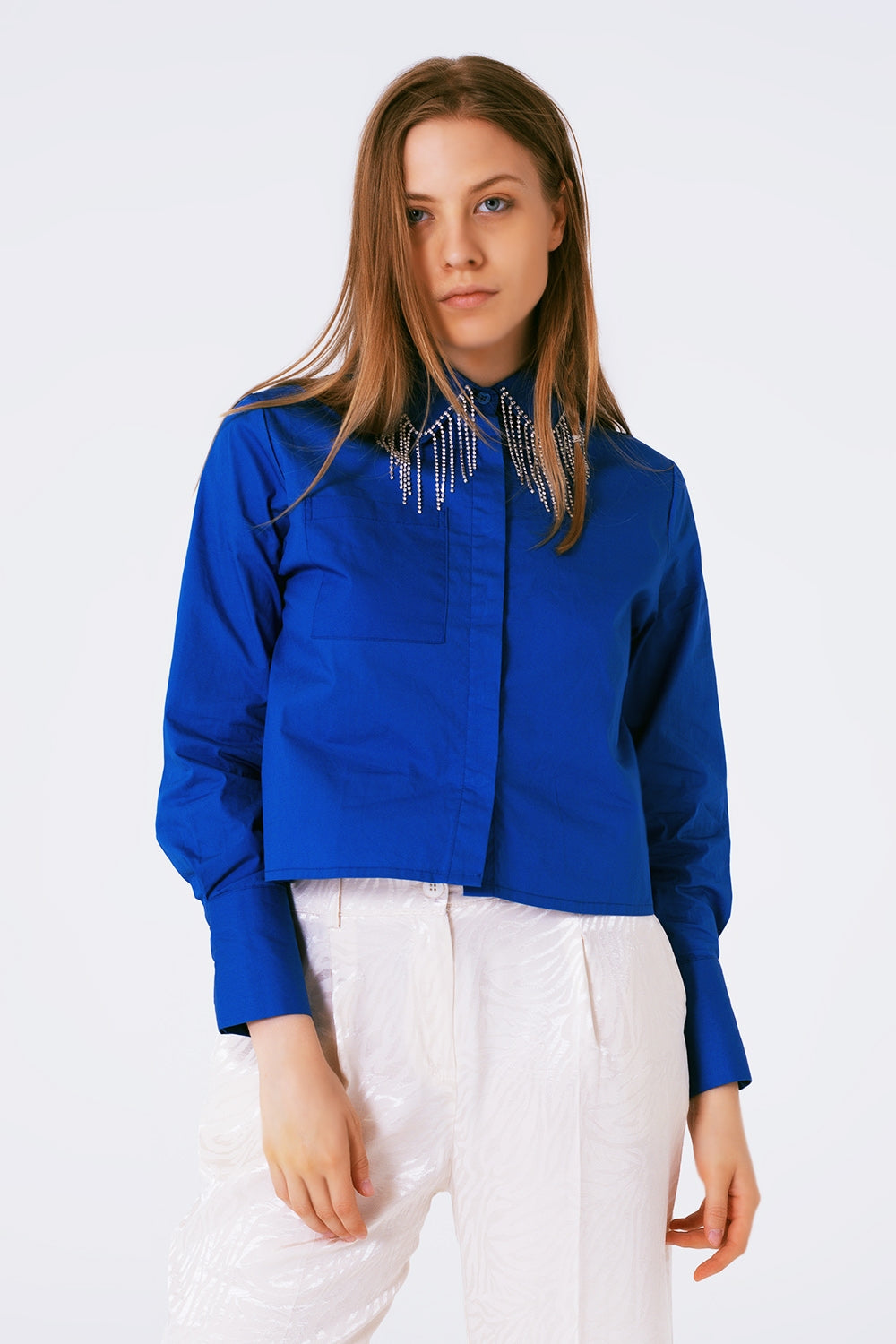 Camisa de algodón en color azul cobalto con flecos de strass colgando del cuello.