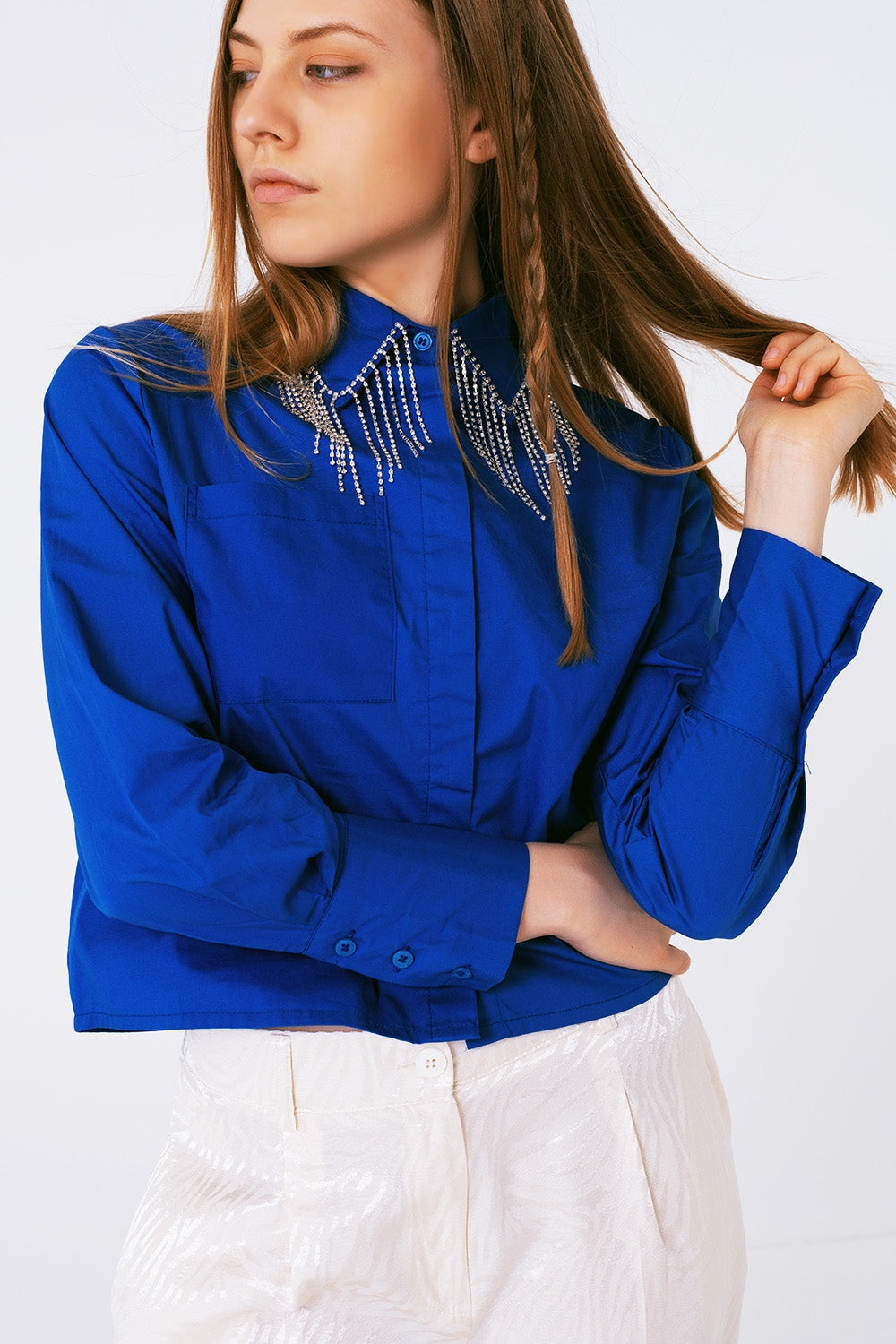 Camisa de algodón en color azul cobalto con flecos de strass colgando del cuello.