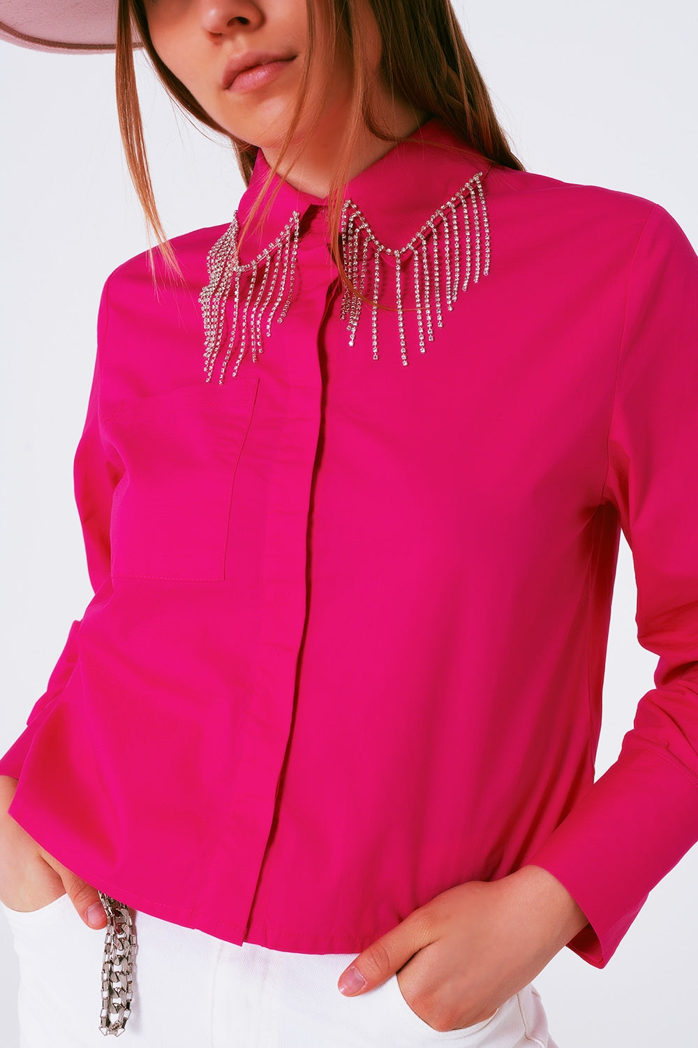 Camisa de algodón en color fucsia con flecos de strass colgando del cuello.