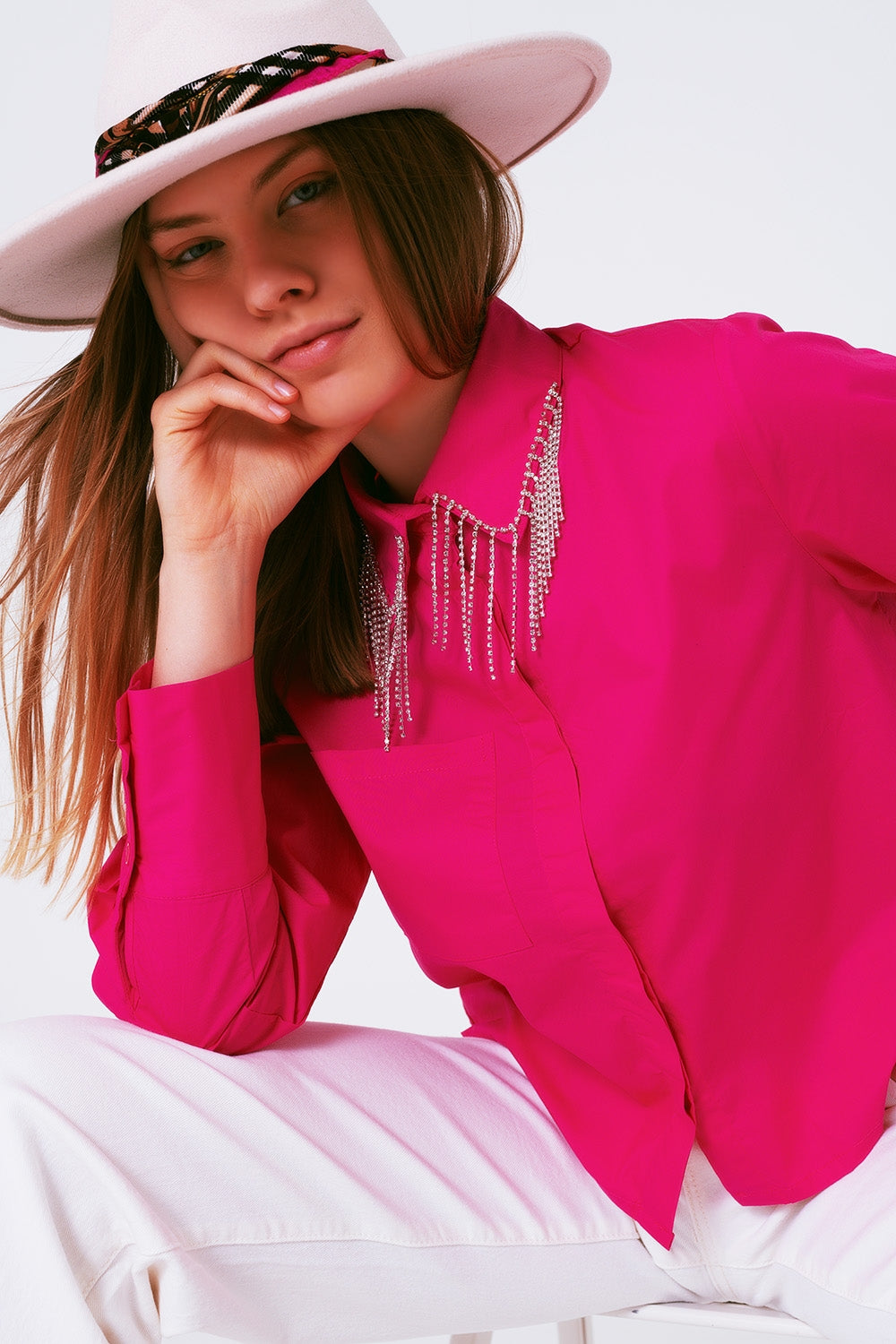 Camisa de algodón en color fucsia con flecos de strass colgando del cuello.