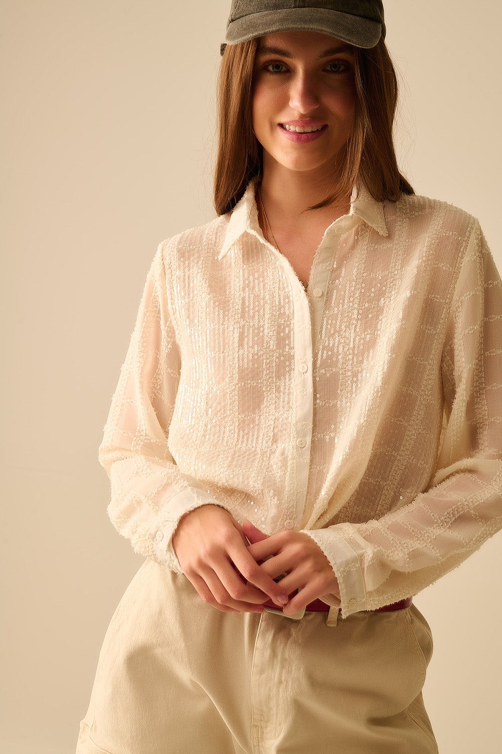 Detalle de lentejuelas y textura a cuadros en la blusa romántica.