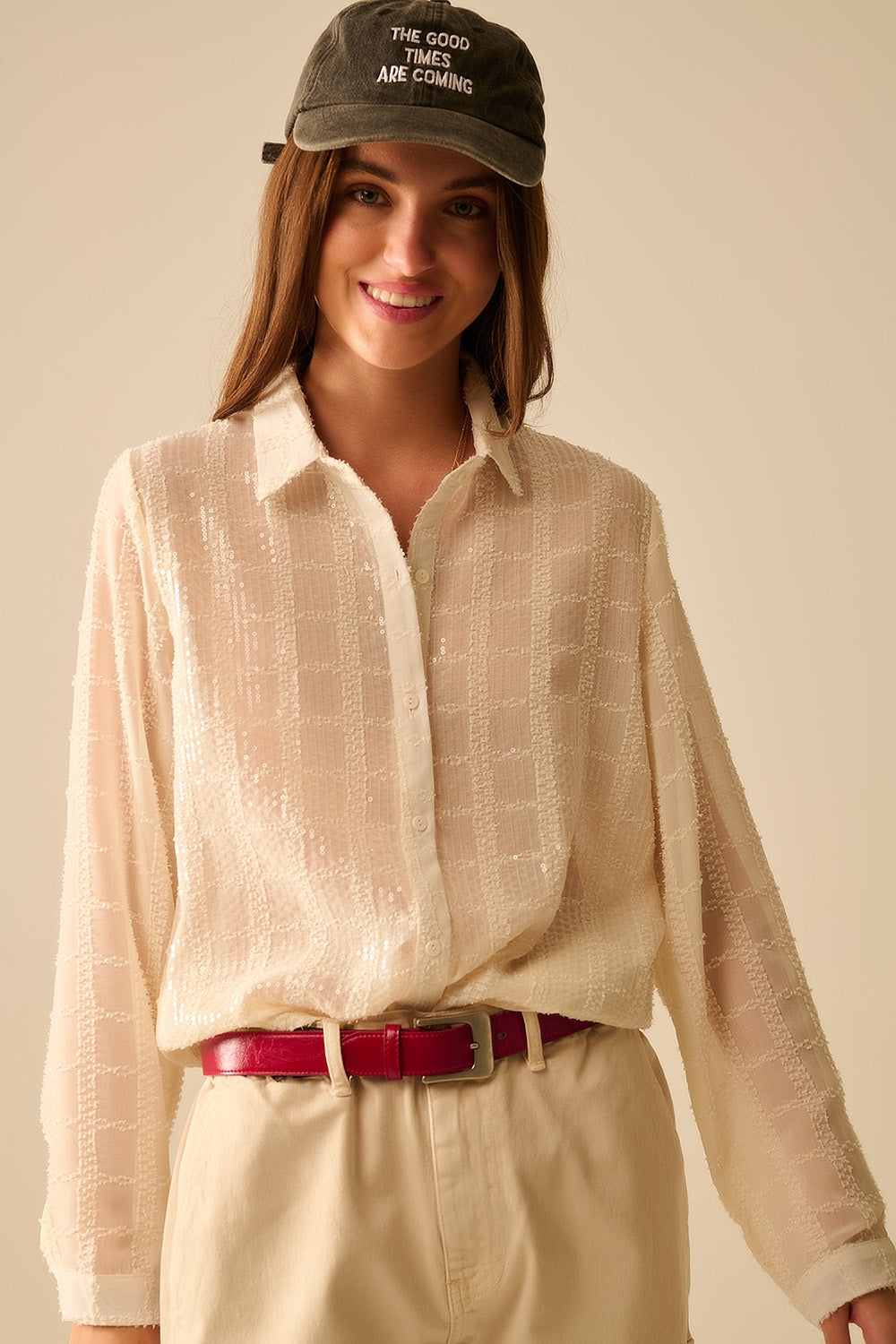 Blusa de lentejuelas romántica en look urbano con gorra y sneakers.