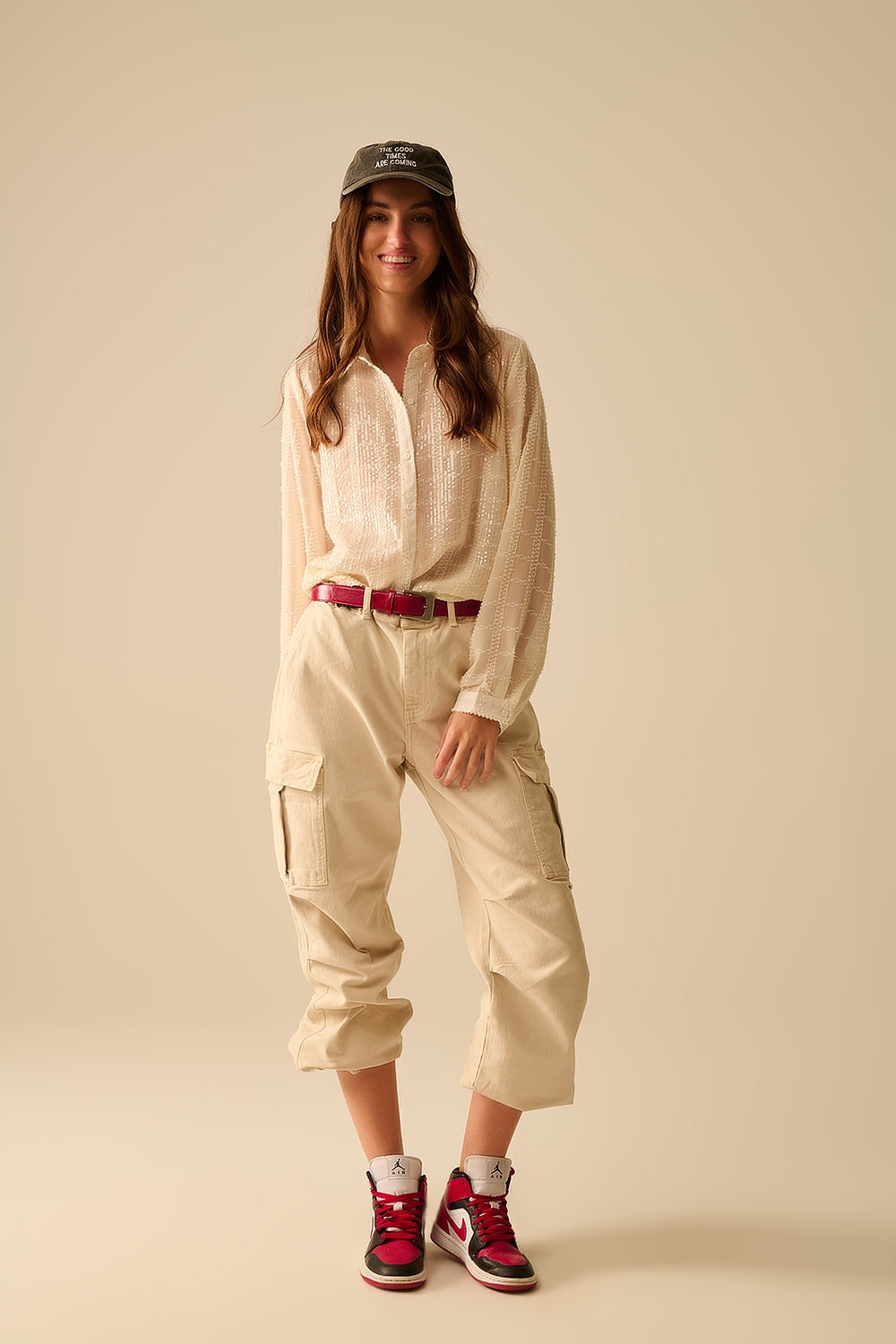 Blusa romántica combinada con pantalón beige y cinturón berry.