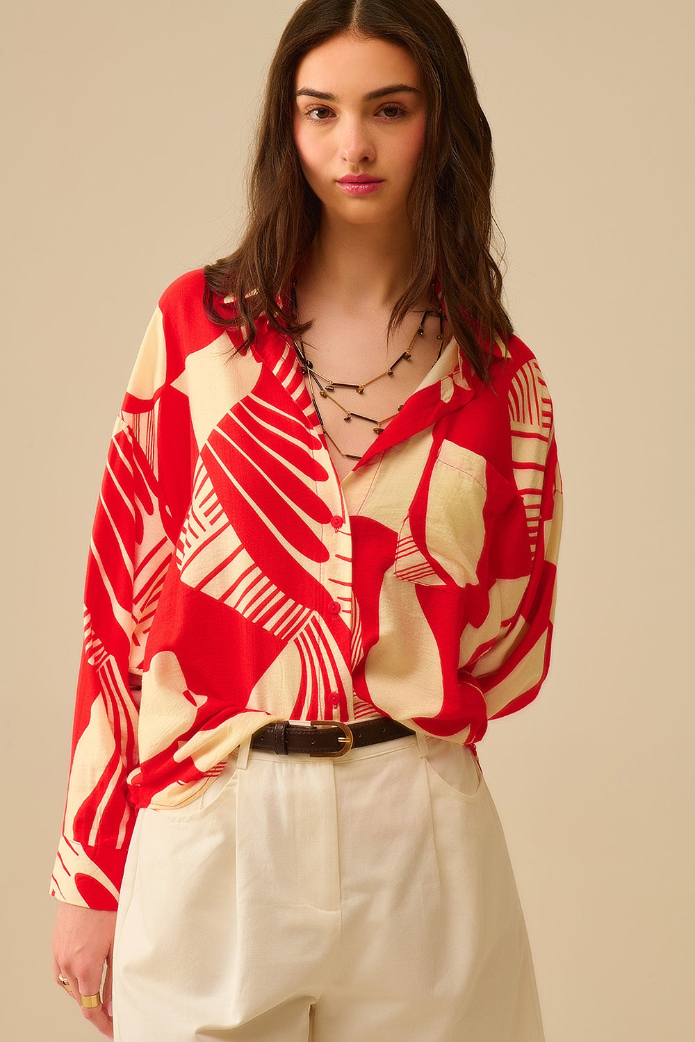 camisa de manga larga con estampado abstracto rojo y blanco, cuello polo y bolsillo en el pecho.