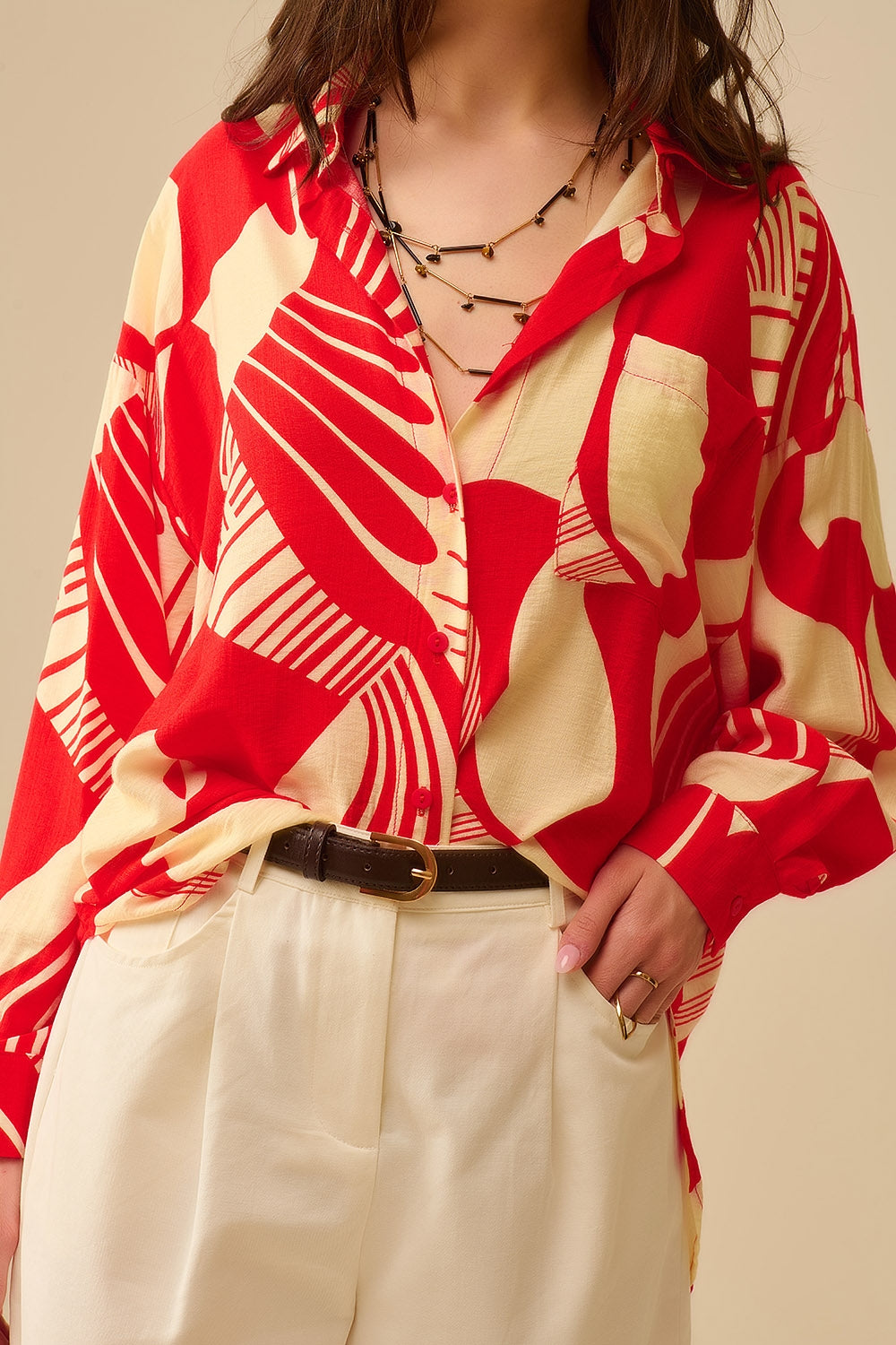 camisa de manga larga con estampado abstracto rojo y blanco, cuello polo y bolsillo en el pecho.