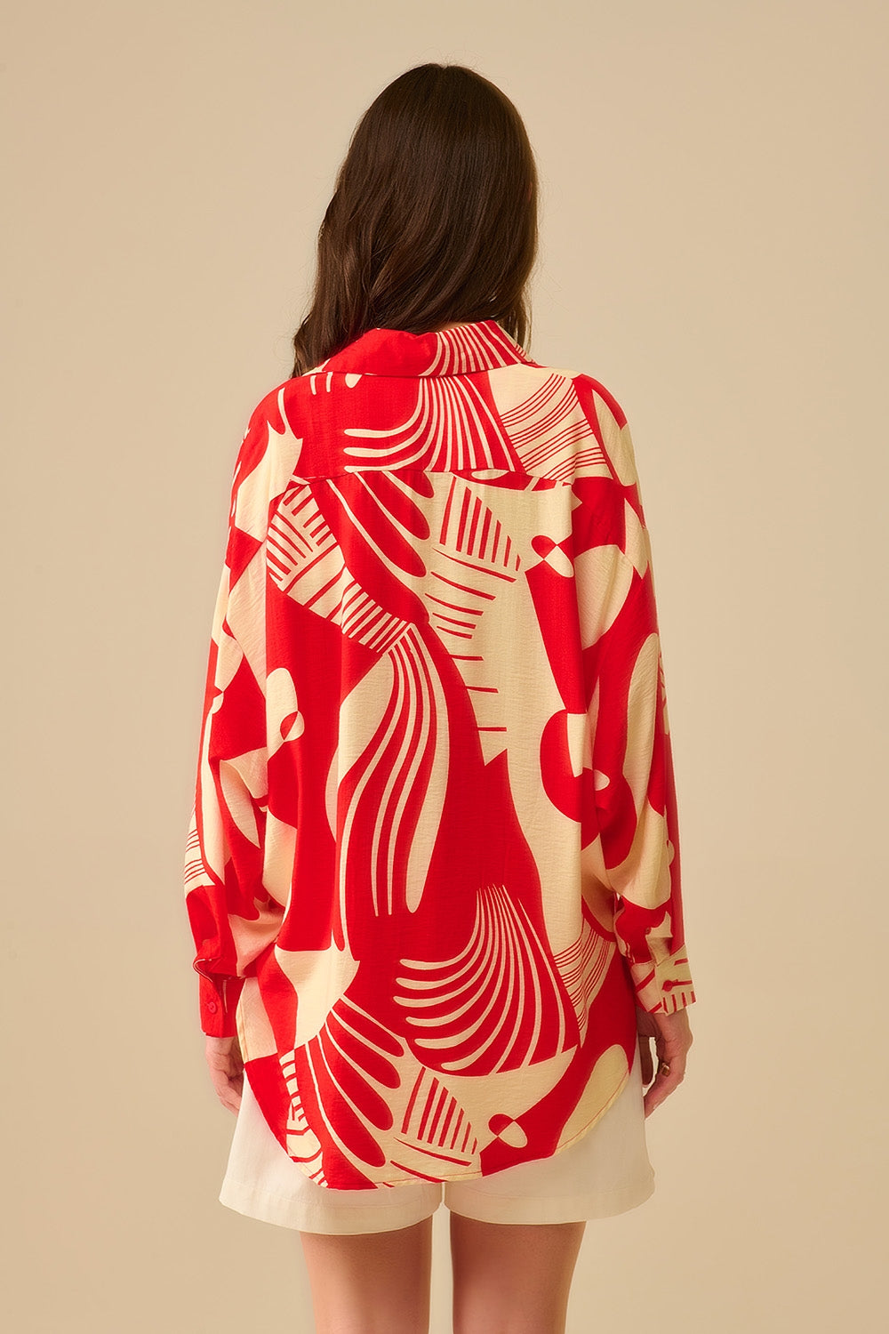 camisa de manga larga con estampado abstracto rojo y blanco, cuello polo y bolsillo en el pecho.