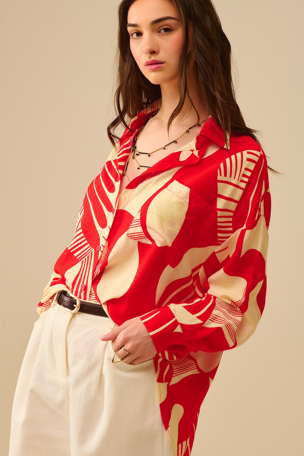 camisa de manga larga con estampado abstracto rojo y blanco, cuello polo y bolsillo en el pecho.