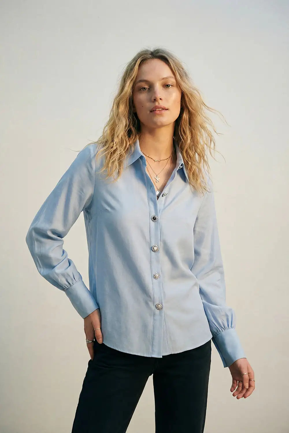 Camisa fluida de lyocell color azul claro con puños anchos y botones joya variados con cristales y zafiro azul.