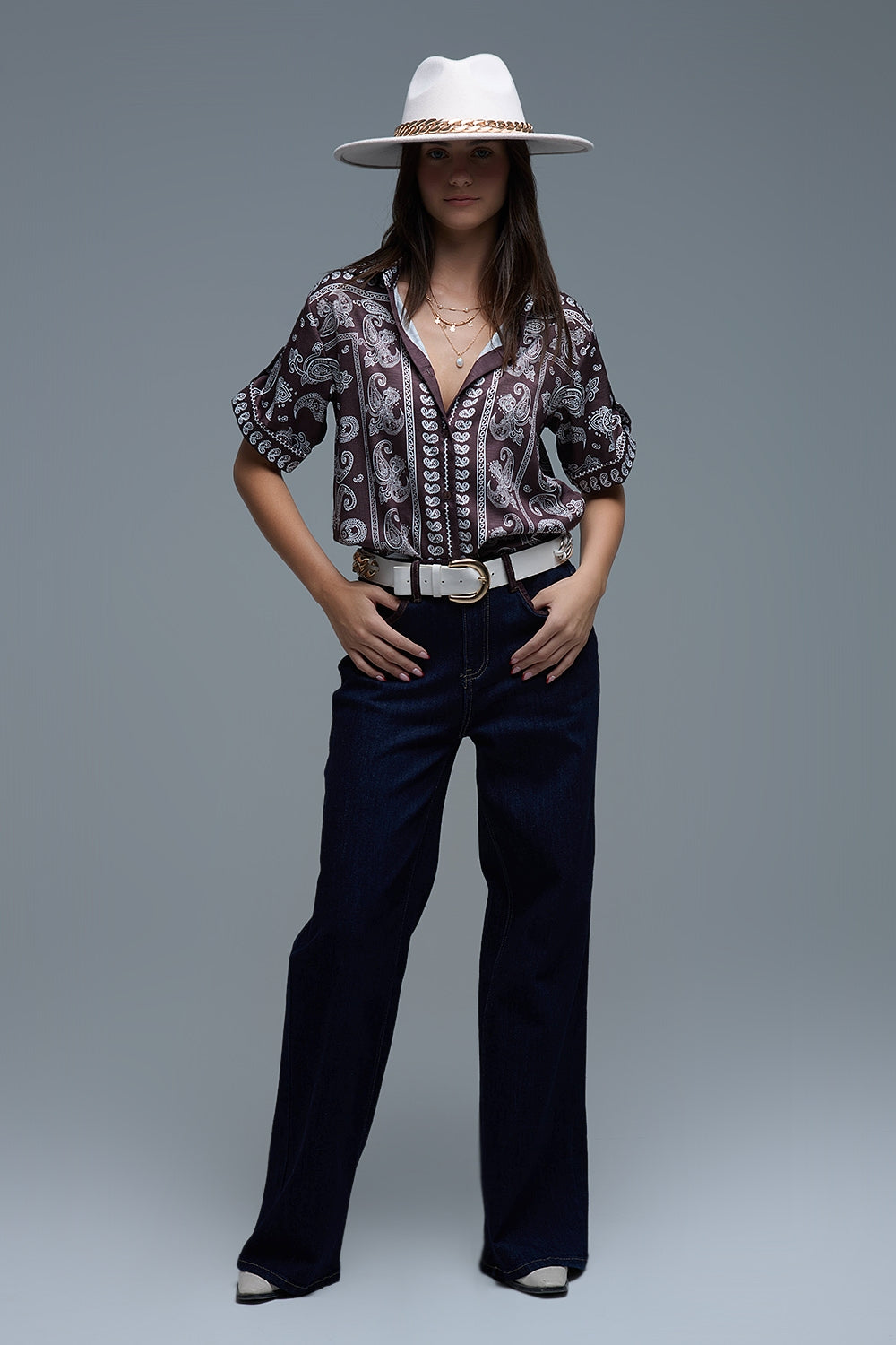 Look completo con camisa paisley marrón y vaqueros oscuros.