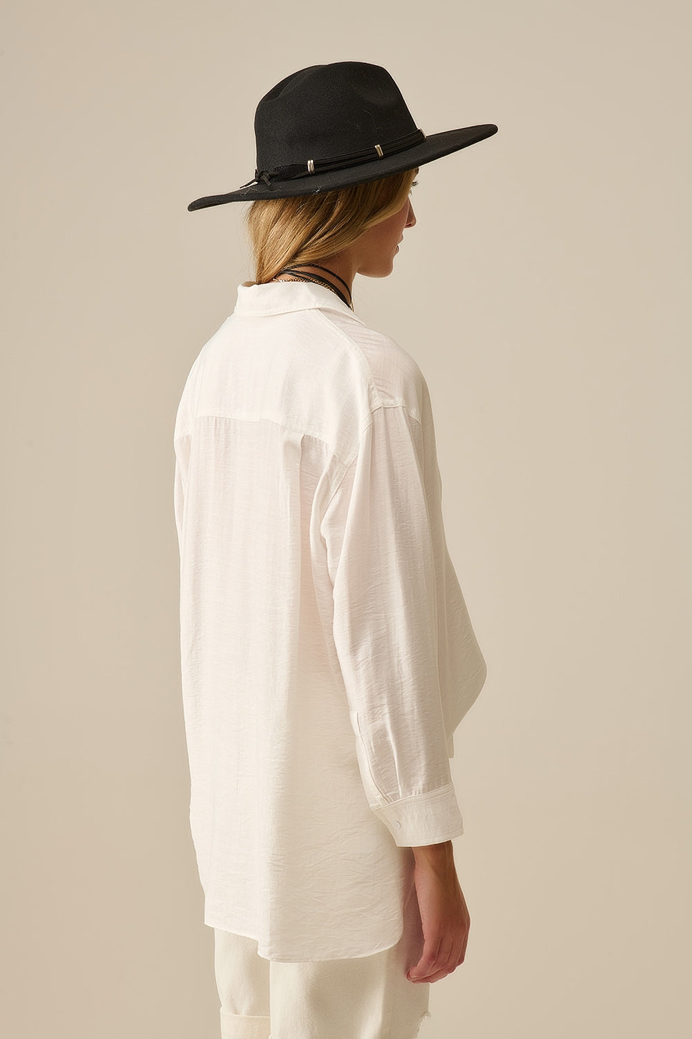 Vista trasera de camisa blanca fluida, corte relajado y tejido ligero, perfecta para primavera-verano.