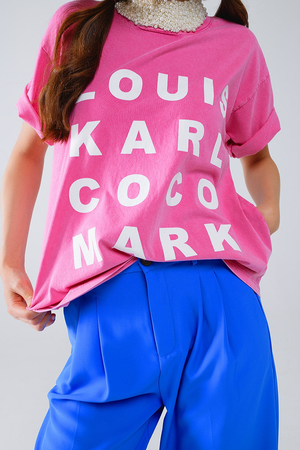 Camiseta fucsia con logotipos de nombres famosos en la parte delantera