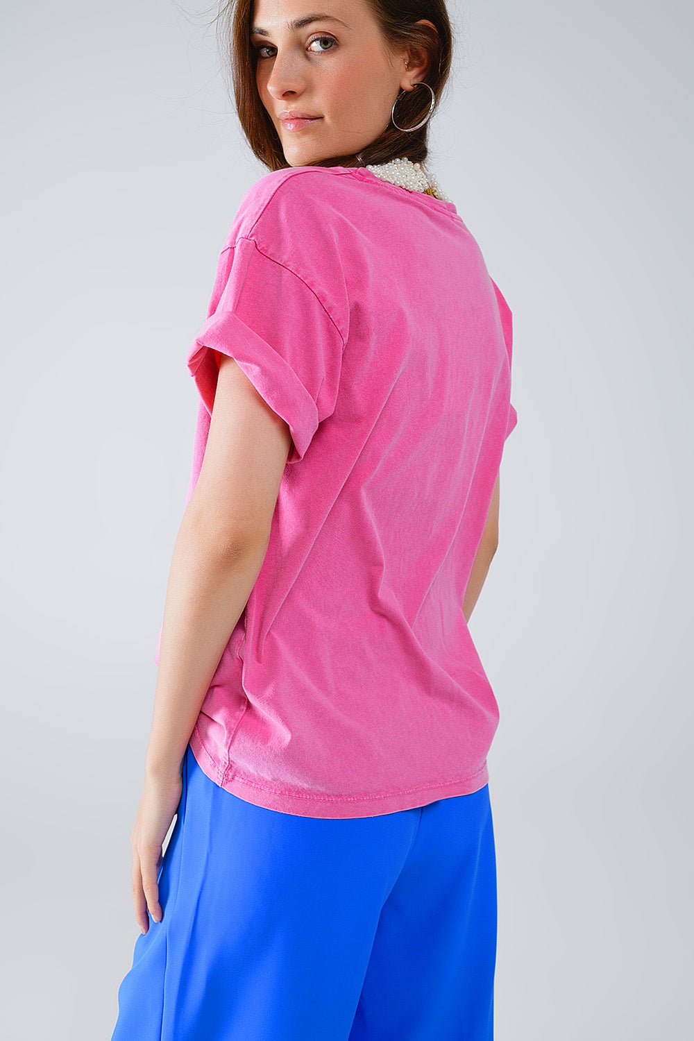 Camiseta fucsia con logotipos de nombres famosos en la parte delantera
