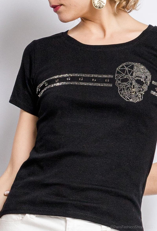 Detalle de calavera decorativa con aplicaciones brillantes sobre camiseta negra de algodón.