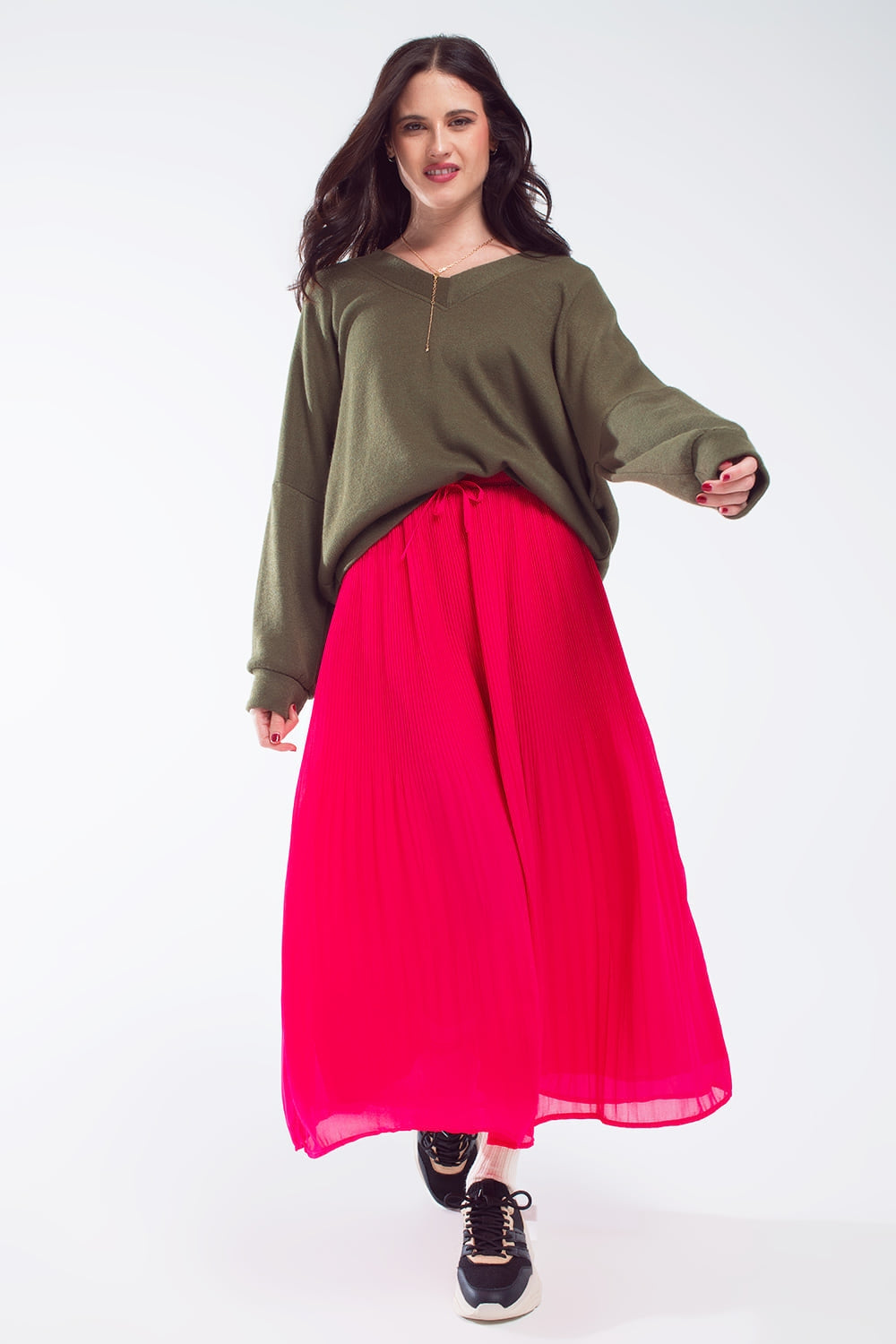 Modelo con jersey fino oversize de manga larga y escote en V en color verde oliva.