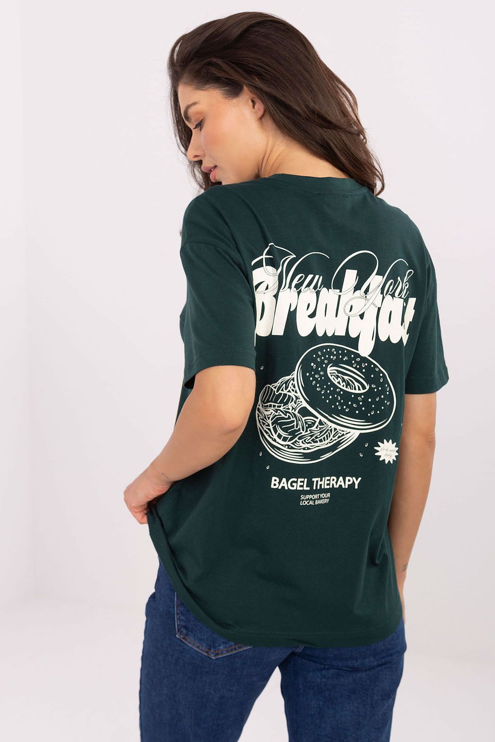 Diseño gráfico en la espalda de camiseta verde con donut y letras "New York Breakfast"