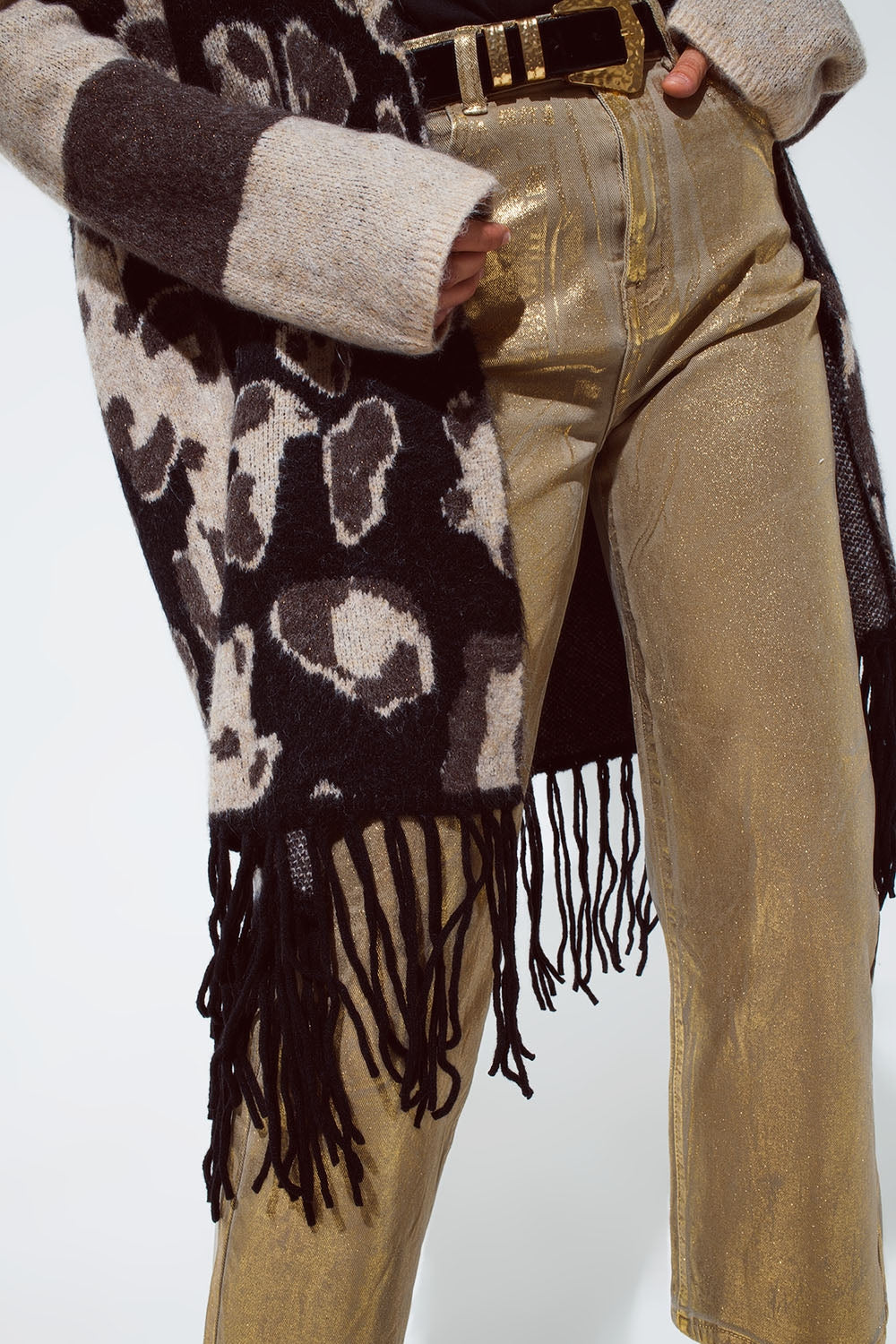 Cárdigan de punto grueso con estampado de leopardo y flecos negros en el bajo.