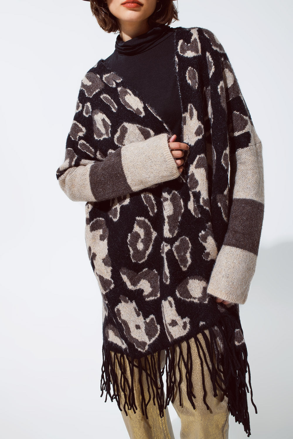 Cárdigan de punto grueso con estampado de leopardo y flecos negros en el bajo.