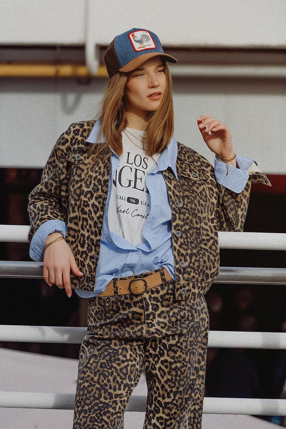 Mujer vistiendo chaqueta vaquera oversized con estampado de leopardo, estilo urbano con gorra y capas