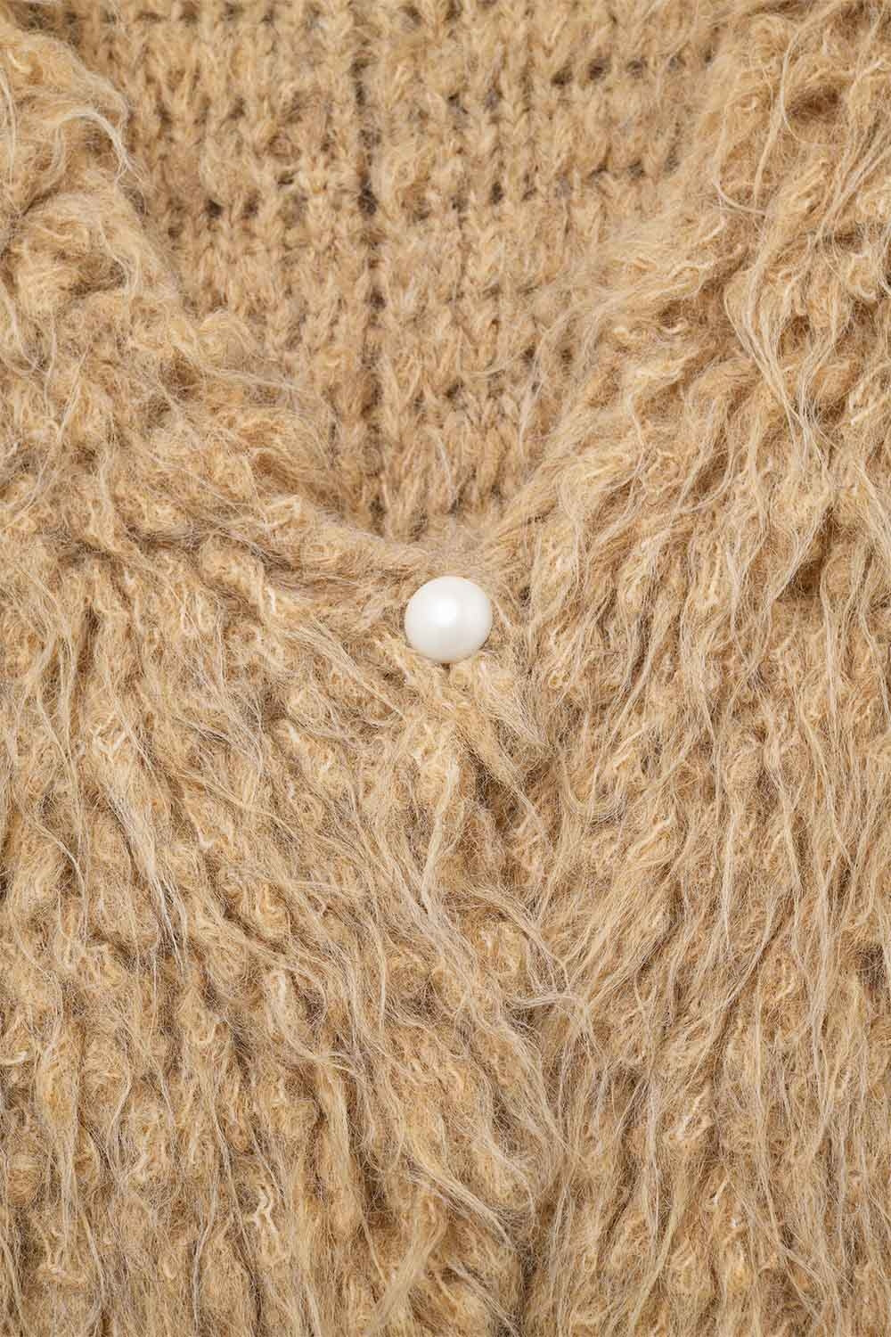 Primer plano de la textura de un tejido de punto con efecto pelo largo en color camel.