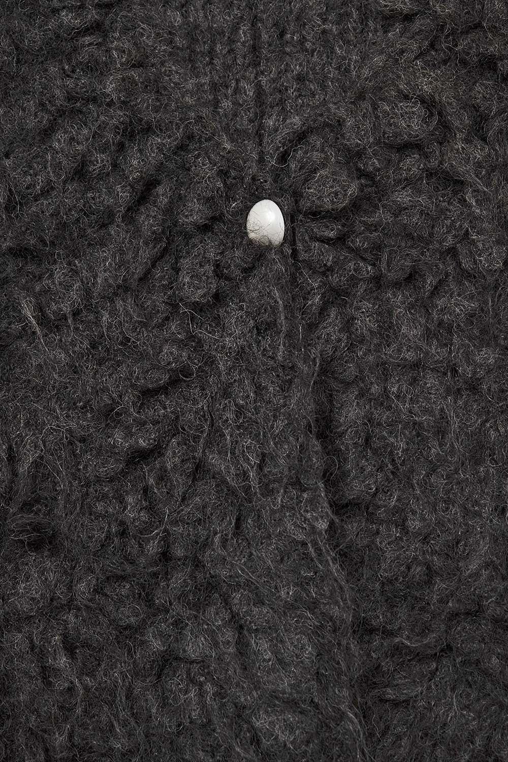 Detalle textura chaleco efecto pelo negro con composición de lana