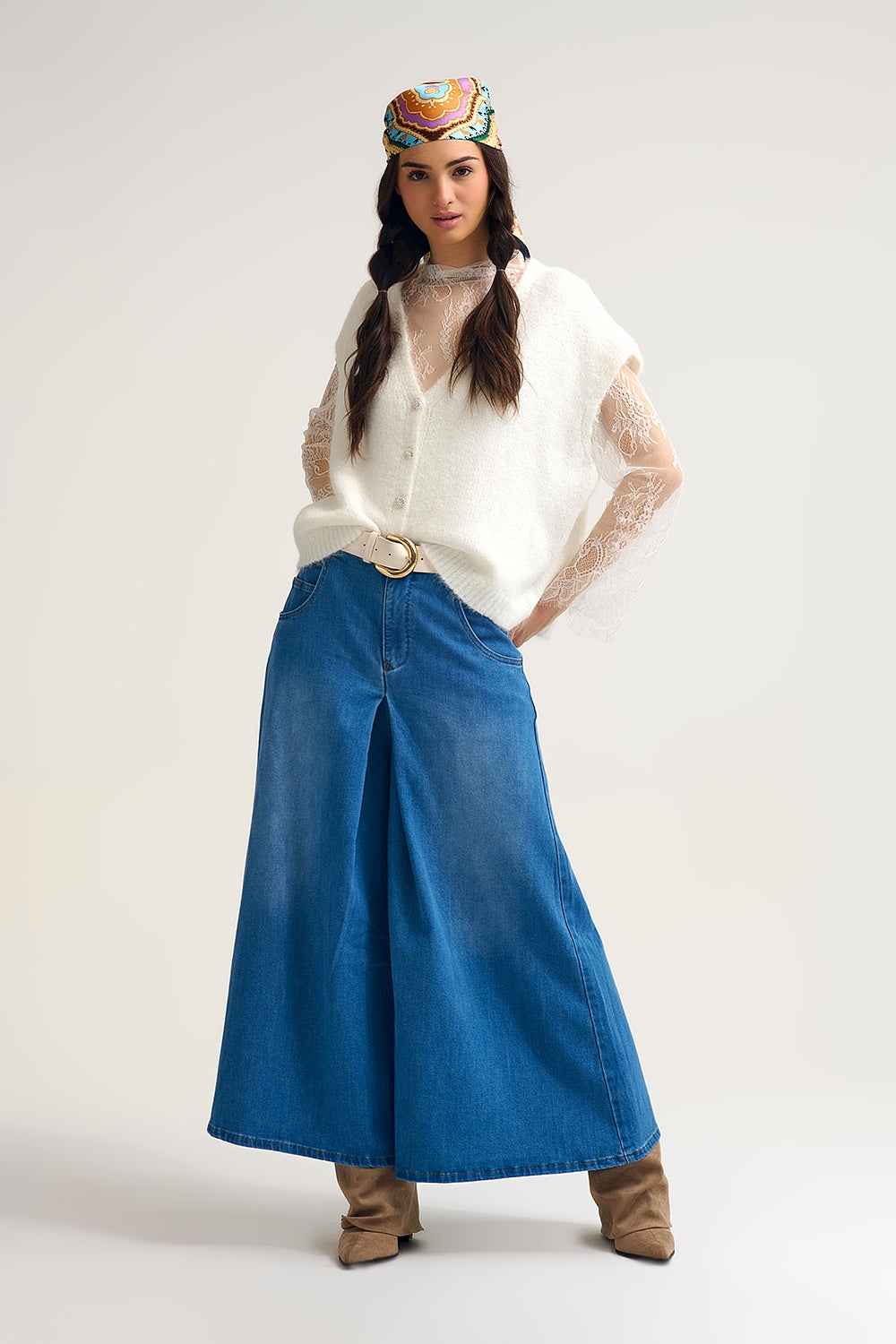 Mujer vistiendo chaleco de punto suave blanco con mangas de encaje floral y botones joya estilo romántico.