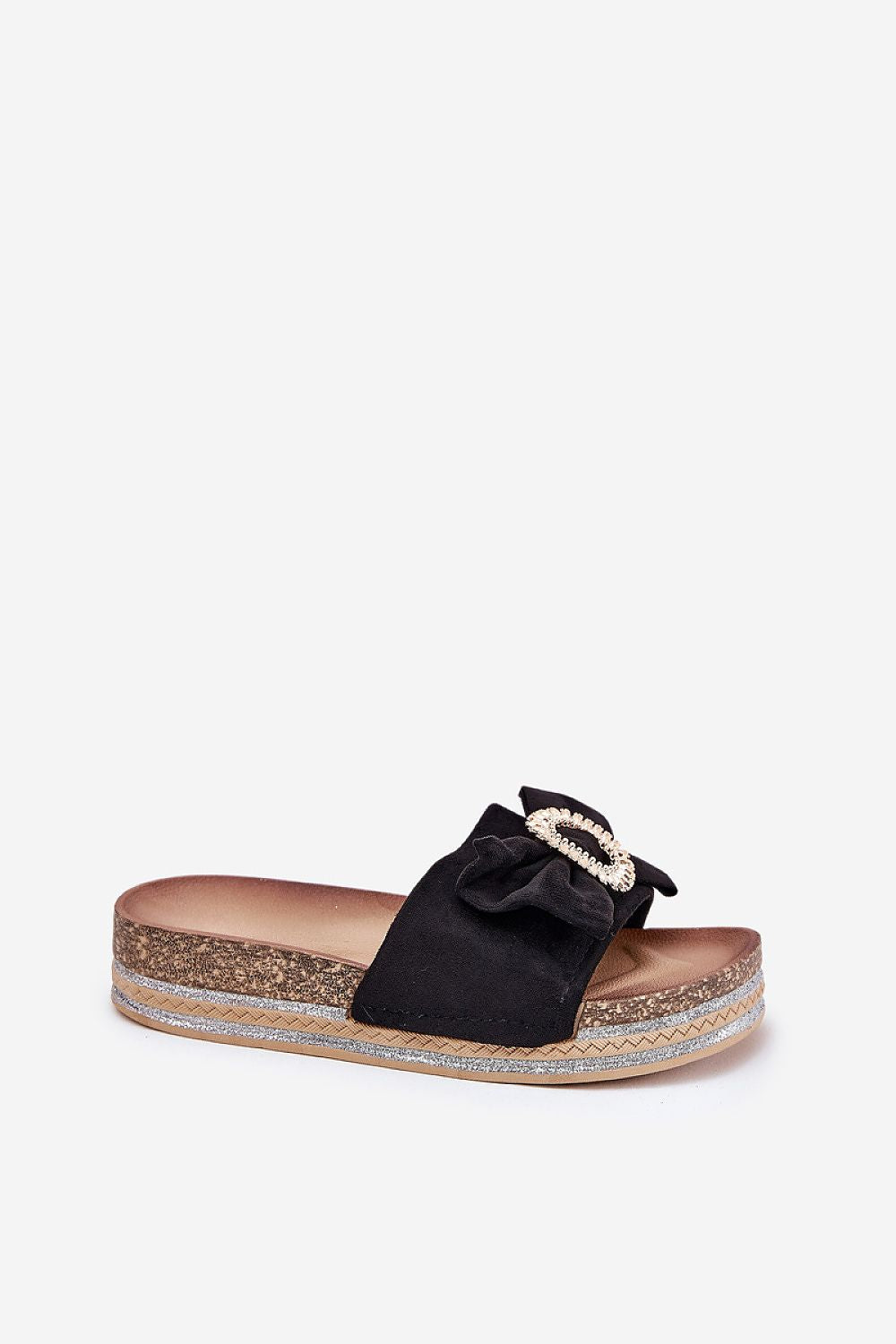  Mujer con chanclas negras de plataforma con lazo y broche decorativo