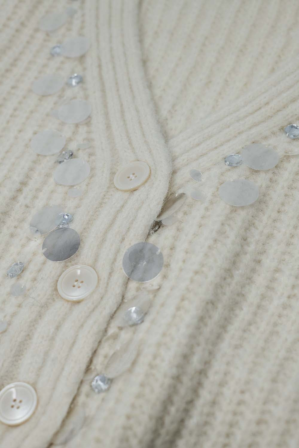 Chaqueta blanca de punto grueso coon detalles de lentejuelas plateadas