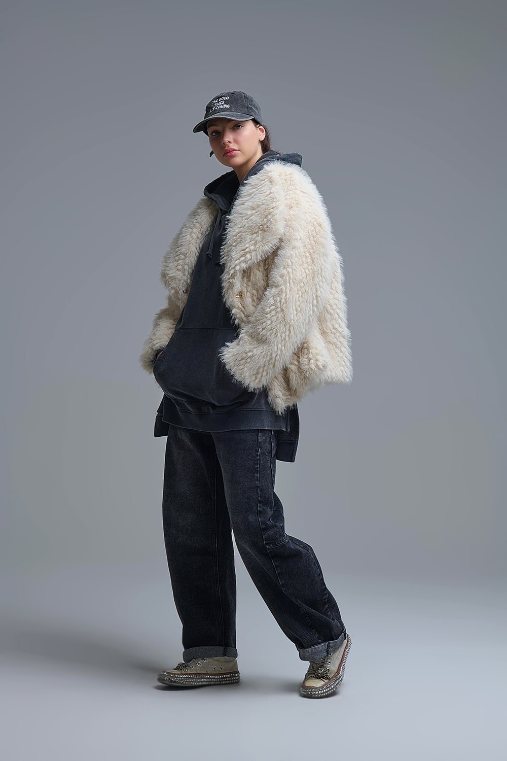 Modelo con chaqueta oversize de pelo sintético "shaggy" en color crudo, sobre una sudadera gris y vaqueros.