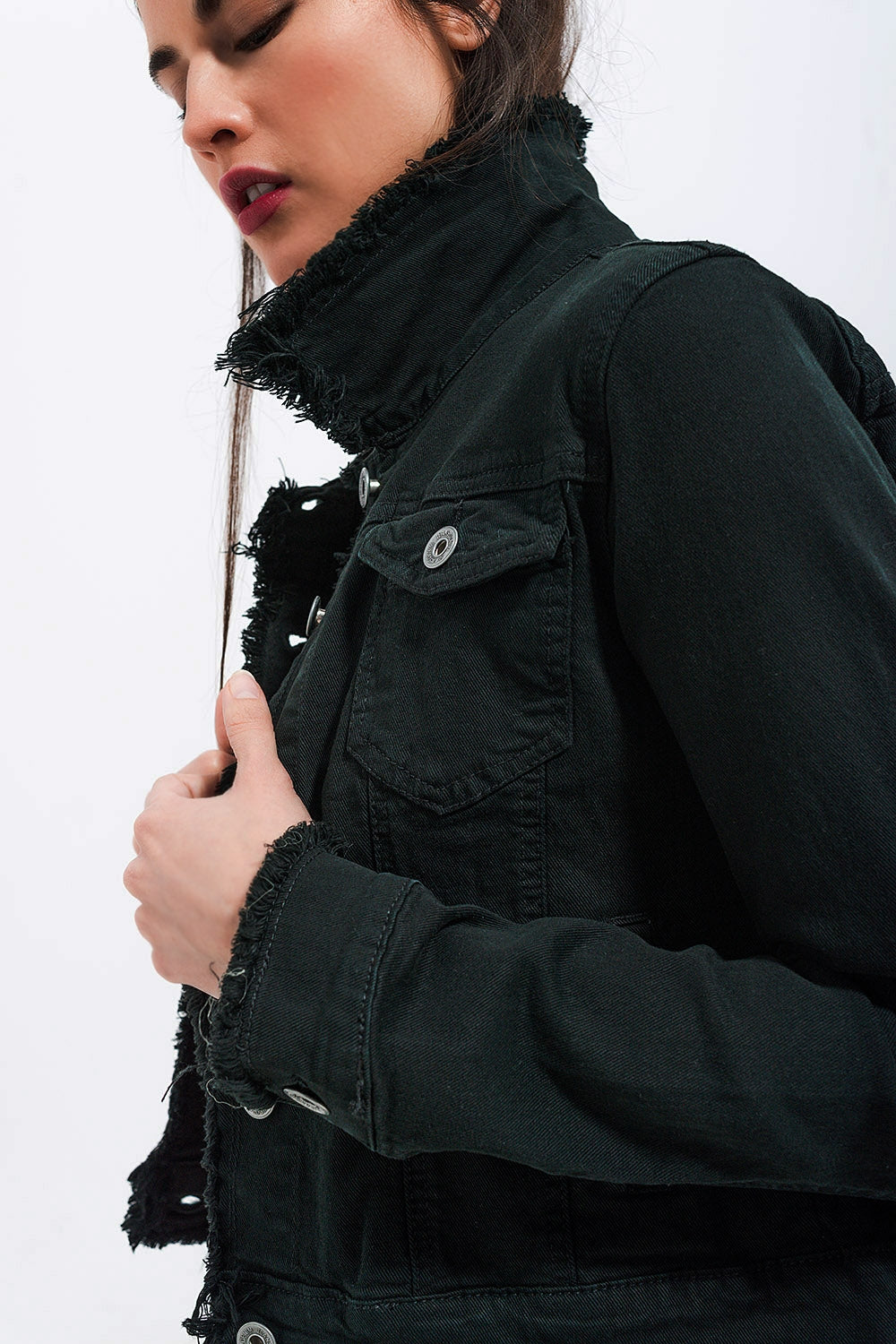 Detalle cuello deshilachado de chaqueta vaquera negra.