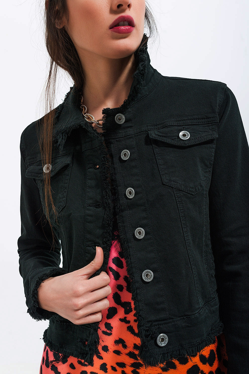 Chaqueta vaquera negra corta con botones metálicos.