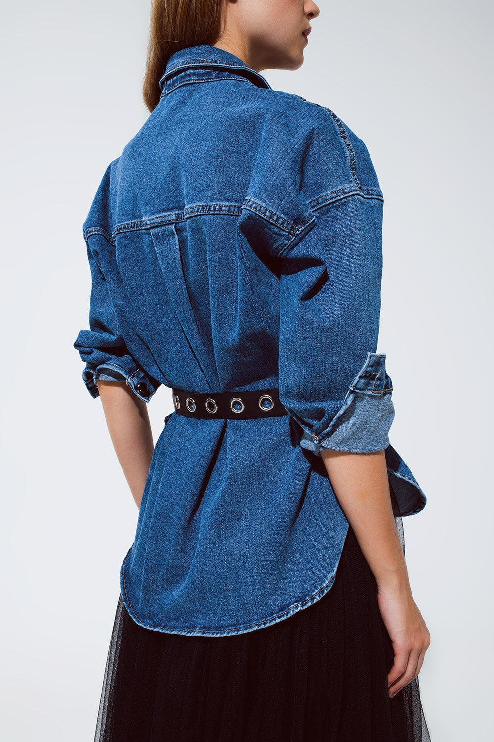 Vista de perfil de un look con sobrecamisa vaquera oversize y bolsillos cargo.