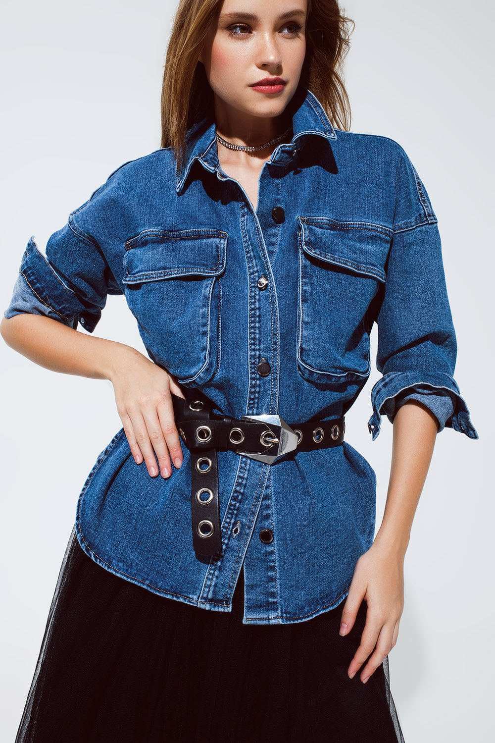 Modelo con chaqueta vaquera oversize con bolsillos cargo, ceñida con un cinturón.