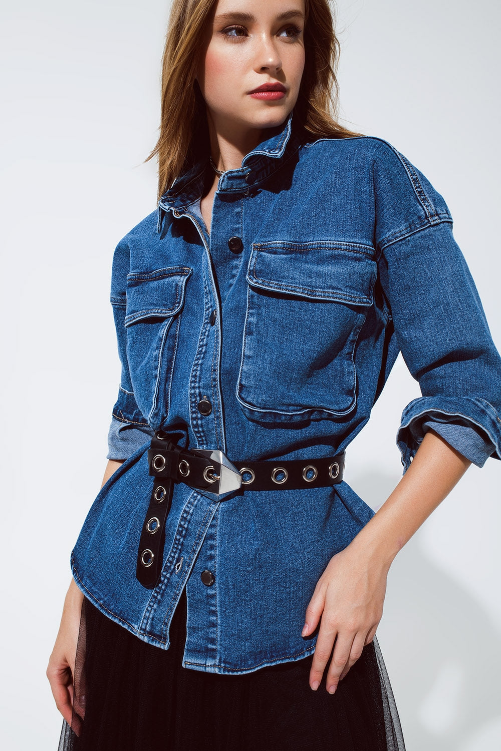 chaqueta vaquera oversize con bolsillos cargo, ceñida con un cinturón.