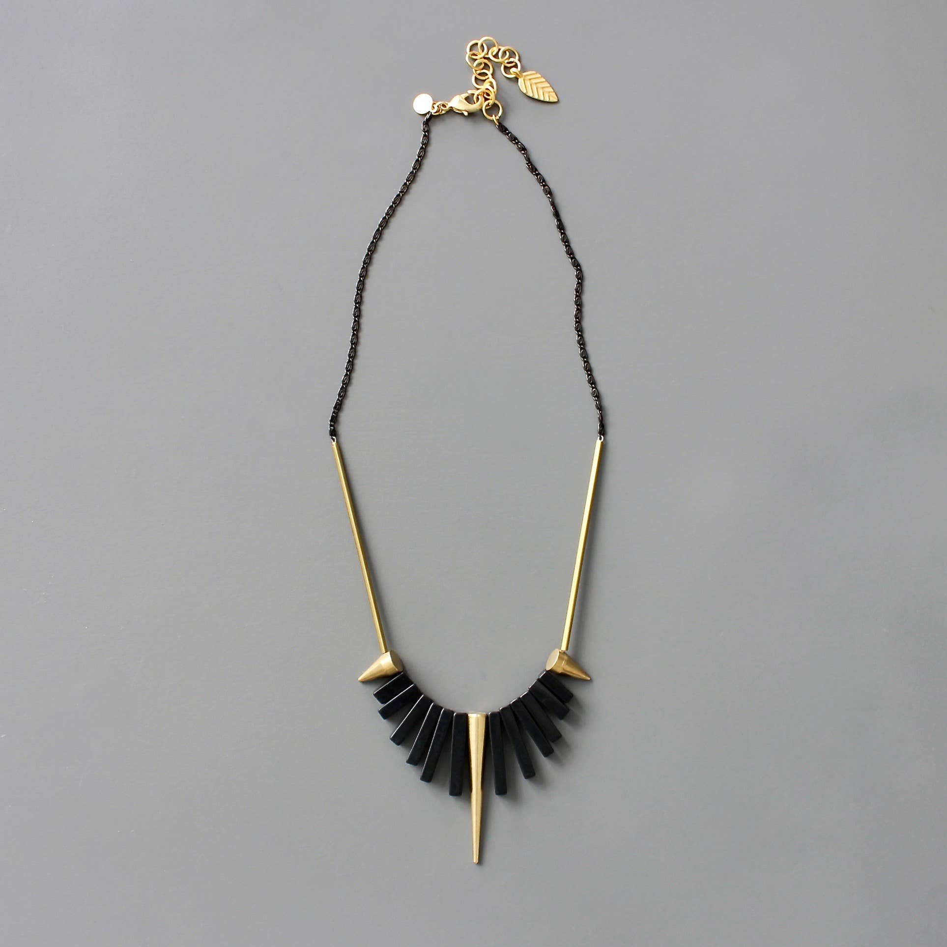 Collar corto de David Aubrey con piedras de ágata negra y detalles de latón dorado. Diseño artesanal exclusivo con extensor. Disponible en Ivoluxt.