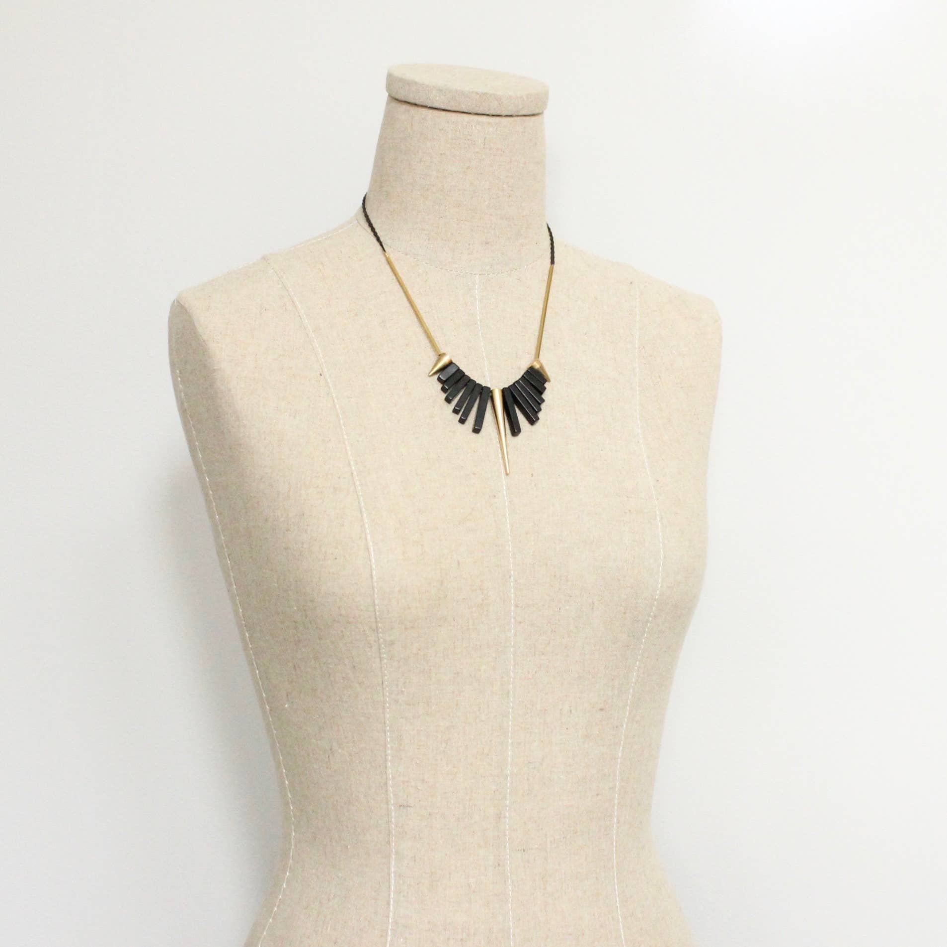Collar corto de David Aubrey con piedras de ágata negra y detalles de latón dorado. Diseño artesanal exclusivo con extensor. Disponible en Ivoluxt.
